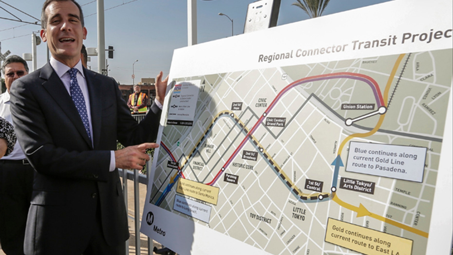 Los Angeles Mayor Eric Garcetti looks at the proposed "Regional Connector Transit Project" plan as he attends a federal grant signing ceremony in Los Angeles Thursday, Feb. 20, 2014. The light rail public transit system in Los Angeles is getting $670 million to solve one of its most vexing design deficiencies: Train riders who want to travel from one side of downtown and out the other must transfer twice. The "regional connector," as the Los Angeles County Metropolitan Transportation Authority calls it, will tie together three existing light rail lines with a new tunnel and three new stations. Major construction should begin later this year, with a cost estimated of $1.4 billion, to be opened in 2020. (AP Photo/Damian Dovarganes)