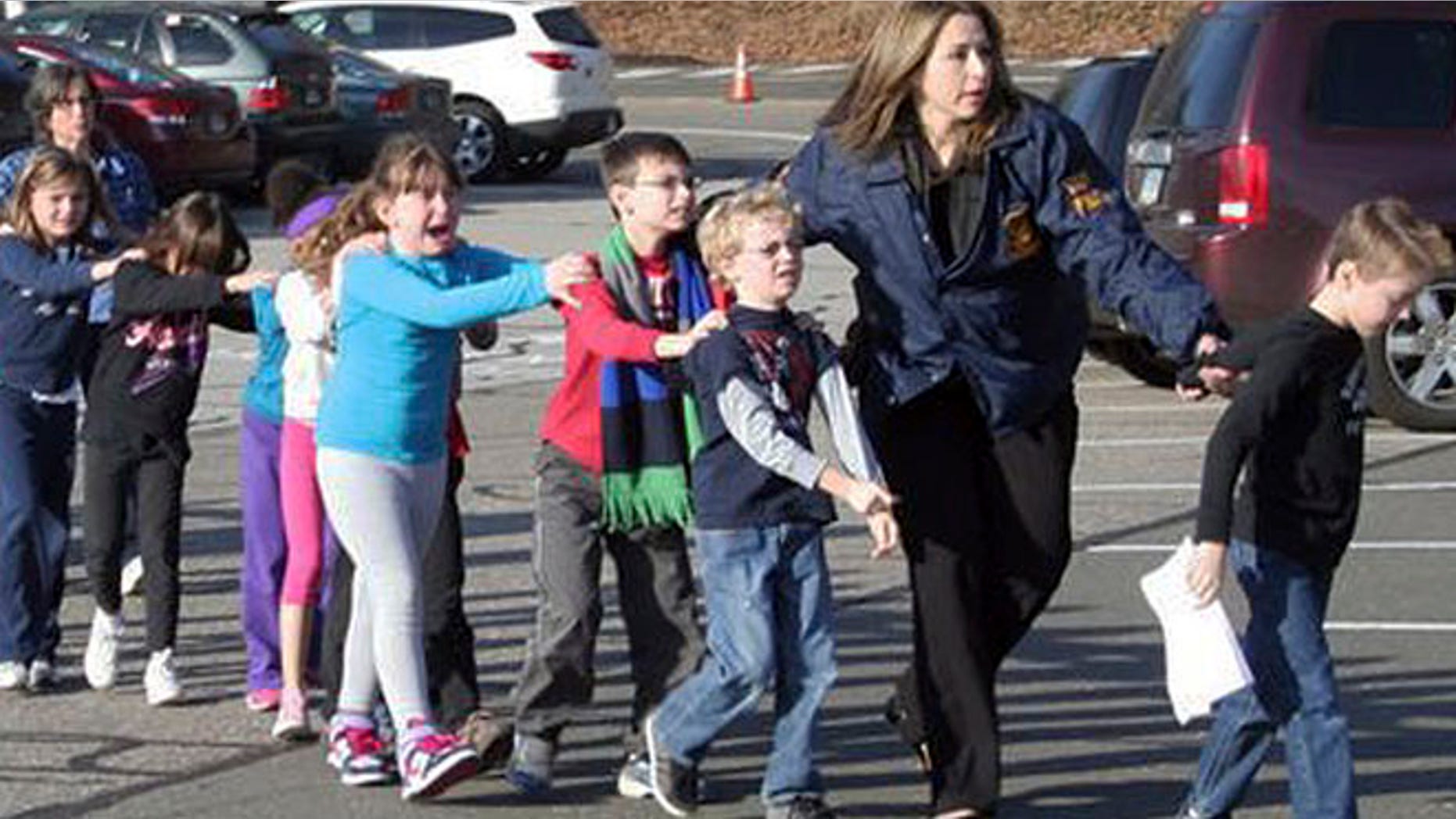 Dec. 14, 2012: In this photo provided by the Newtown Bee, Connecticut State Police lead children from the Sandy Hook Elementary School in Newtown, Conn., following a reported shooting there.