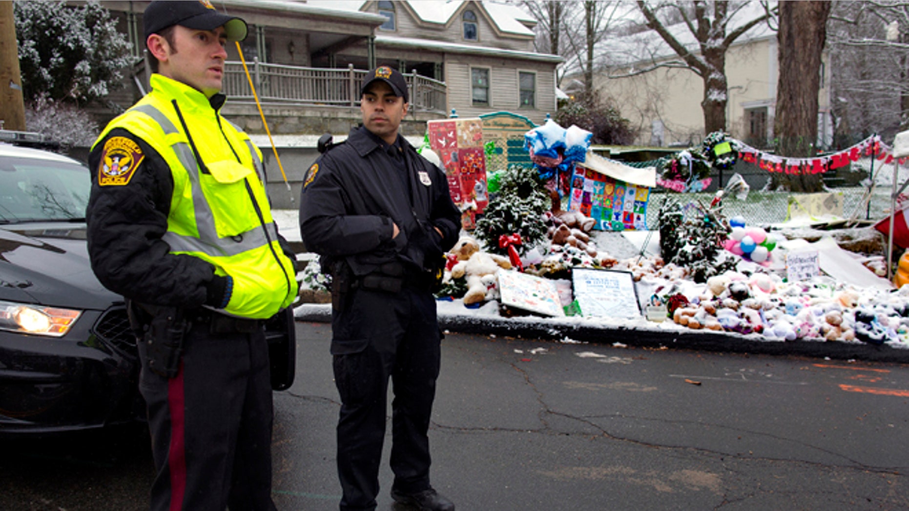 Dec. 25, 2012: From left, Town of Ridgefield, Conn., Det. Durling, and Town of Greenwich, Conn., Officer Rivera stand near a memorial in Newtown, Conn.