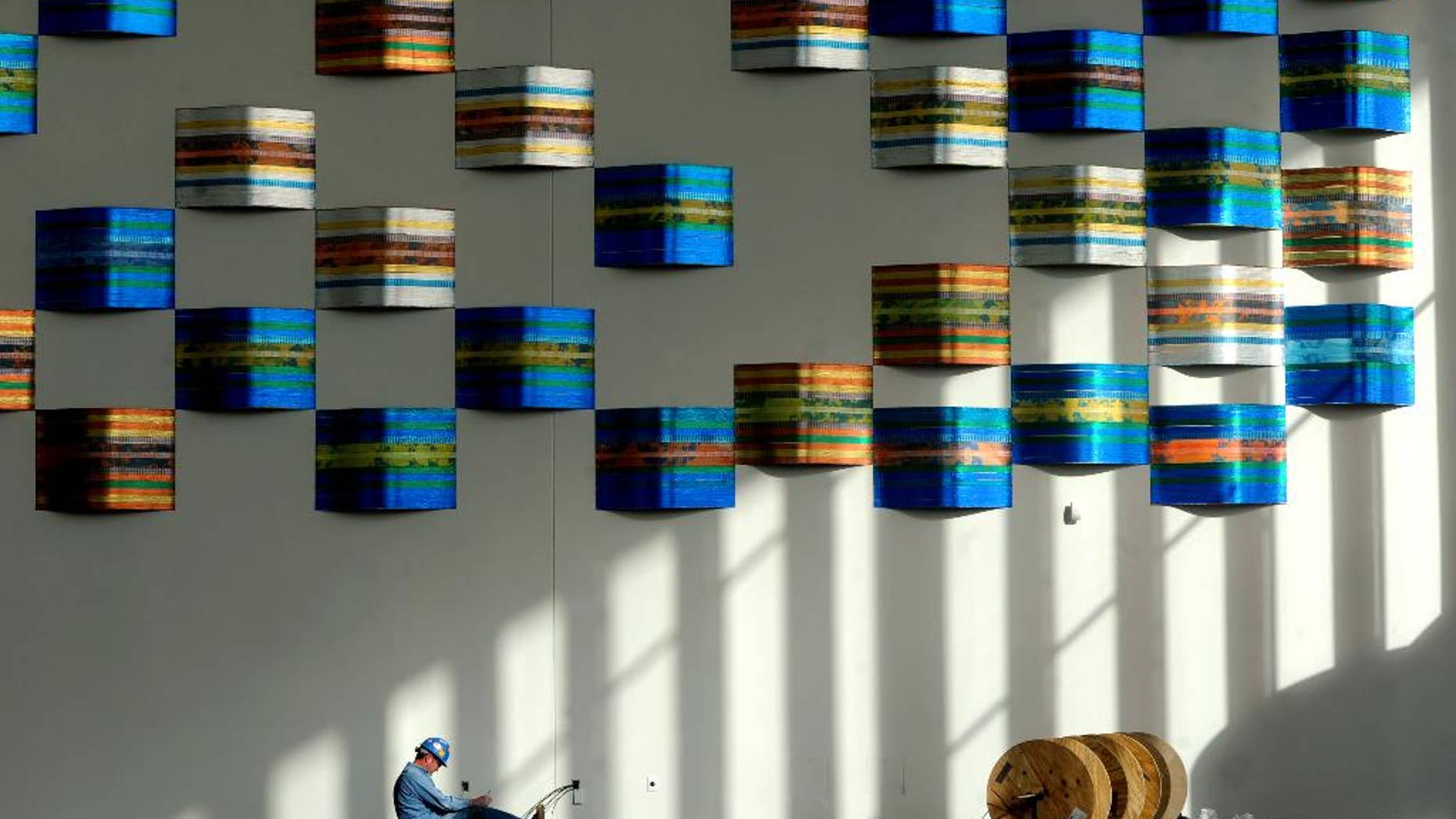FILE - In this Jan. 27, 2014 file photo, Shelby Whitledge, an electrician with Beltline Electric company, works on electrical data in the lobby of the downtown Owensboro Convention Center in Owensboro, Ky. The Commerce Department reports on U.S. construction spending in January on Monday, March 3, 2014. (AP Photo/ Messenger-Inquirer, Jenny Sevcik)