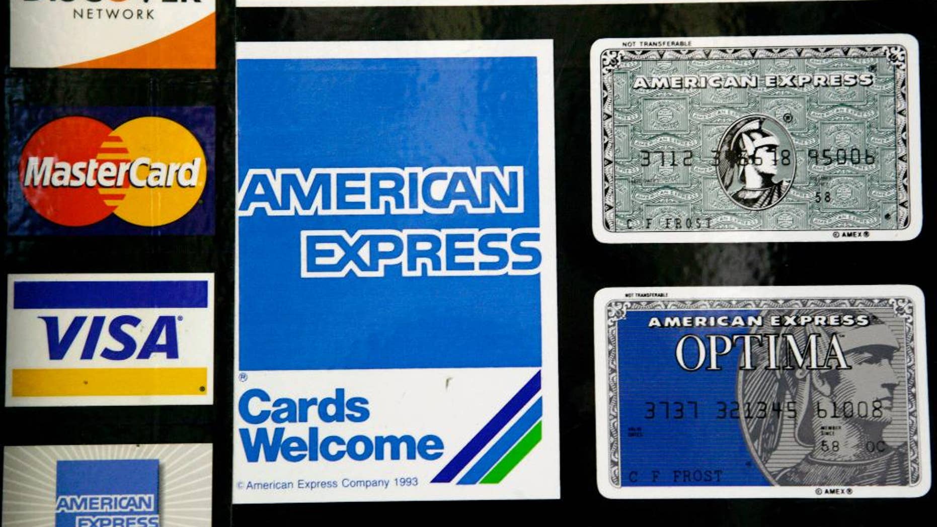FILE - This Sept. 5, 2007, file photo shows credit card decals on a store window in the Hollywood section of Los Angeles. The Federal Reserve reports on consumer borrowing in May on Tuesday, July 8, 2014. (AP Photo/Nick Ut, File)