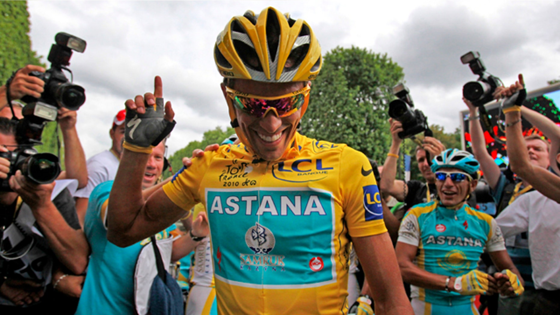 July 25, 2010: Three-time Tour de France winner Alberto Contador of Spain is flanked by teammates and photographers after the 20th and last stage of the tour.