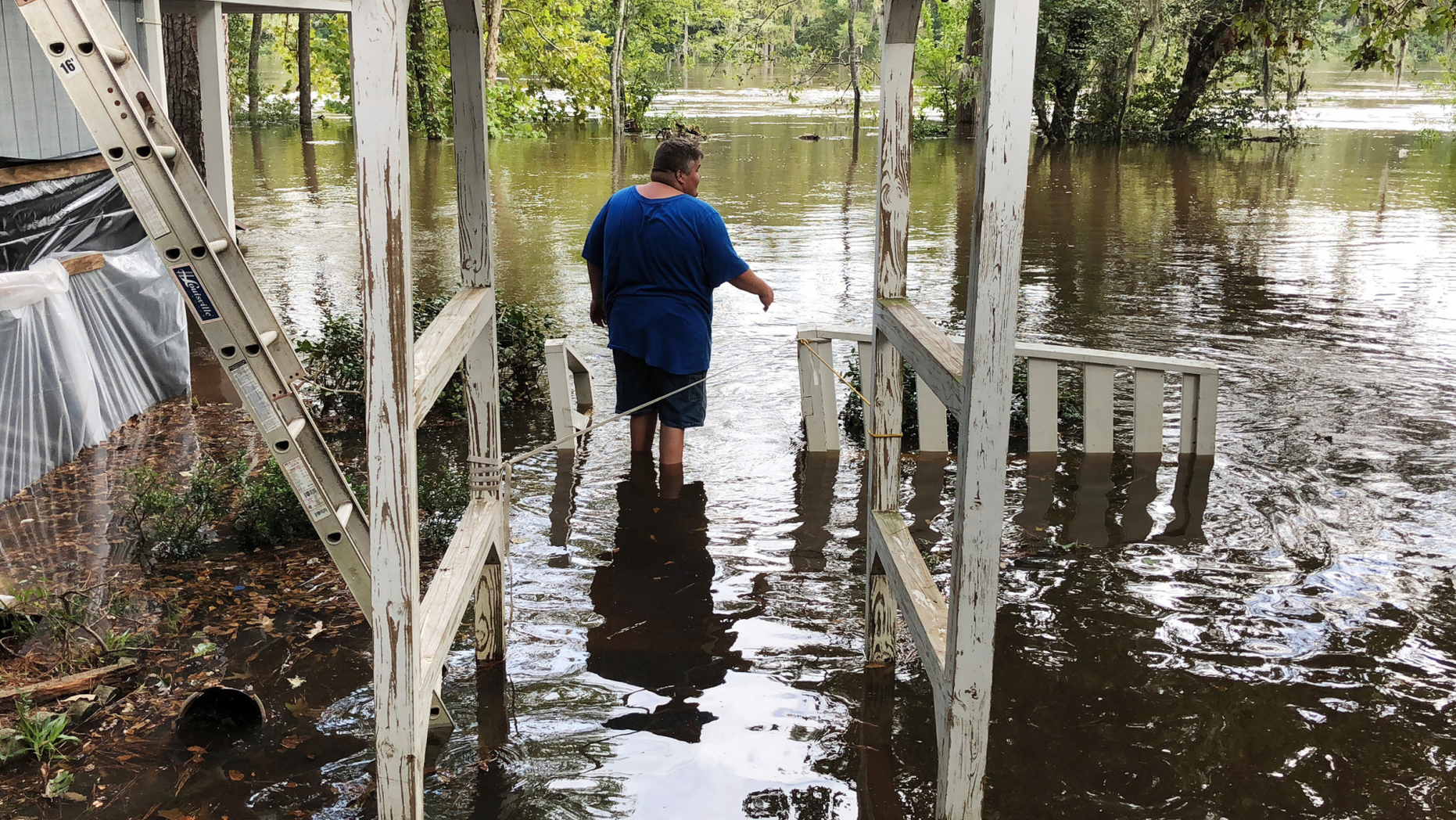 Shawn Lowrimore, Pastor Willie Lowrimore of The Fellowship With Jesus Ministries', son, wades into water near the church in Yauhannah, S.C., on Monday, Sept. 24, 2018. The church is on the bank of the Waccamaw River which has already risen above its record crest and is expected to keep rising for several days, forcing thousands of evacuations in the aftermath of Hurricane Florence. (AP Photo/Jeffrey S. Collins)