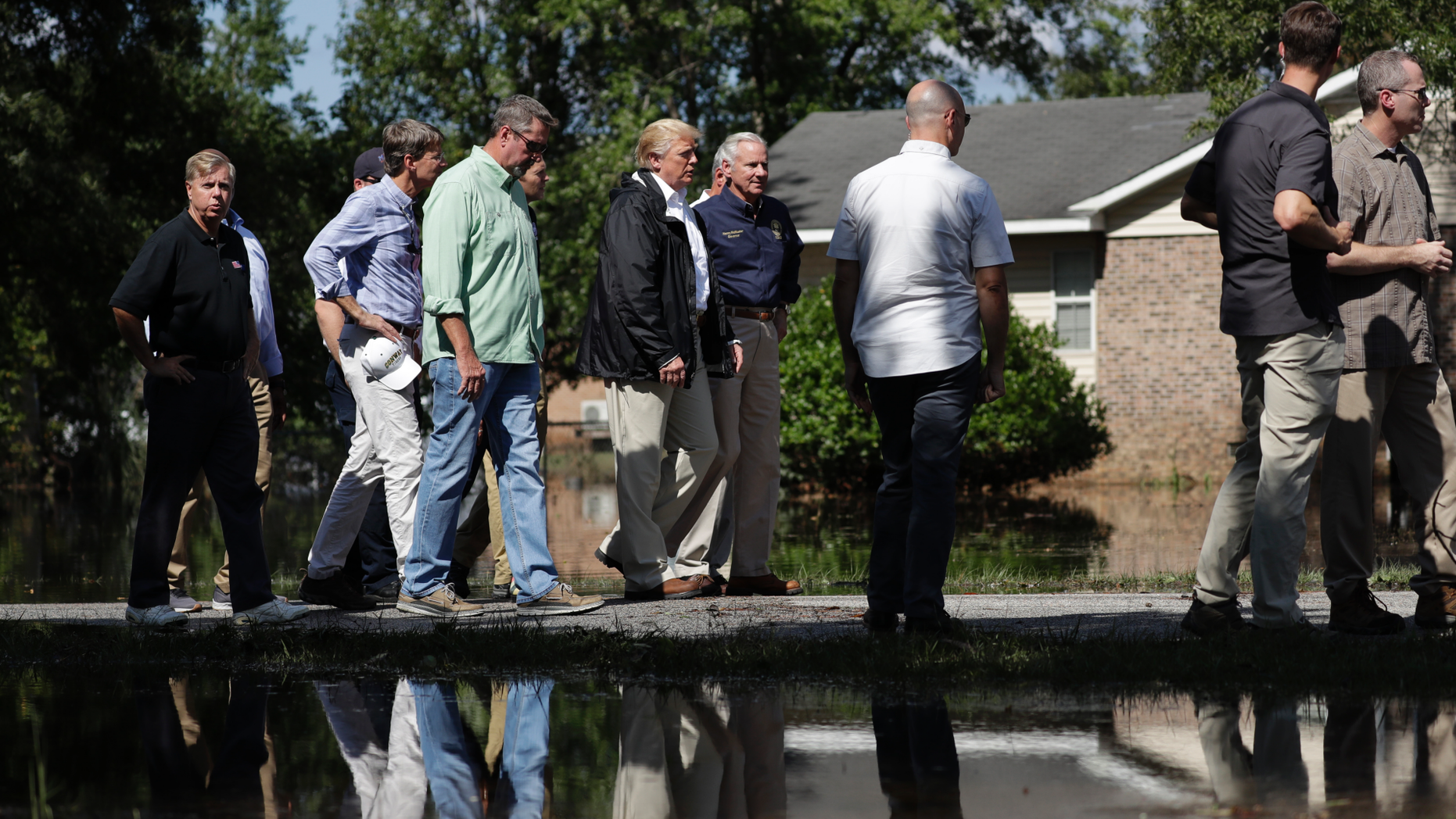 President Donald Trump visits a neighborhood impacted by Hurricane Florence, Wednesday, Sept. 19, 2018, in Conway, S.C. Next to Trump is South Carolina Gov. Henry McMaster. (AP Photo/Evan Vucci)