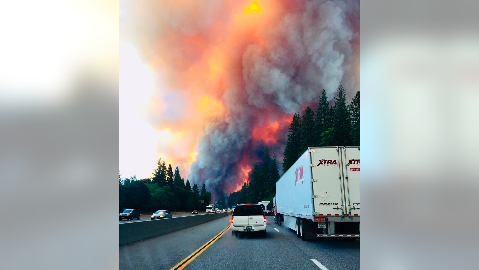 A fire rages as motorists travel on Interstate 5 near Lake Shasta, Calif., Wednesday, Sept. 5, 2018. (Jerri Tubbs via AP)