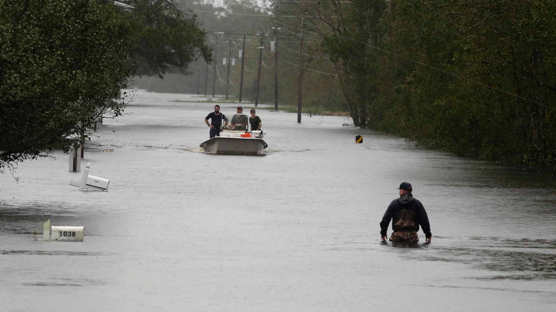 A member of the U.S. Coast Guard walks down Mill Creek Road checking houses after tropical storm Florence hit Newport N.C., Saturday, Sept. 15, 2018. (AP Photo/Tom Copeland)