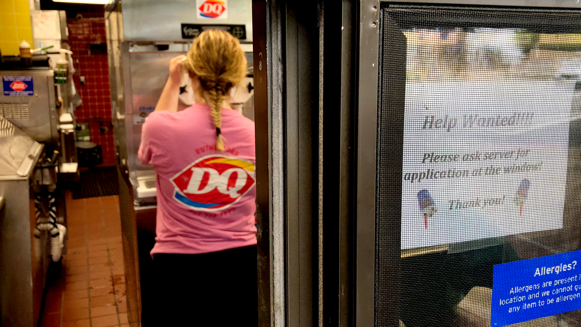 FILE - In this Sunday, Aug. 19, 2018, file photo a woman prepares a cup of ice cream behind a "Help Wanted" sign at a Dairy Queen fast food restaurant in Rutherford, N.J. On Tuesday, Sept. 11, the Labor Department reports on job openings and labor turnover for July. (AP Photo/Ted Shaffrey, File)