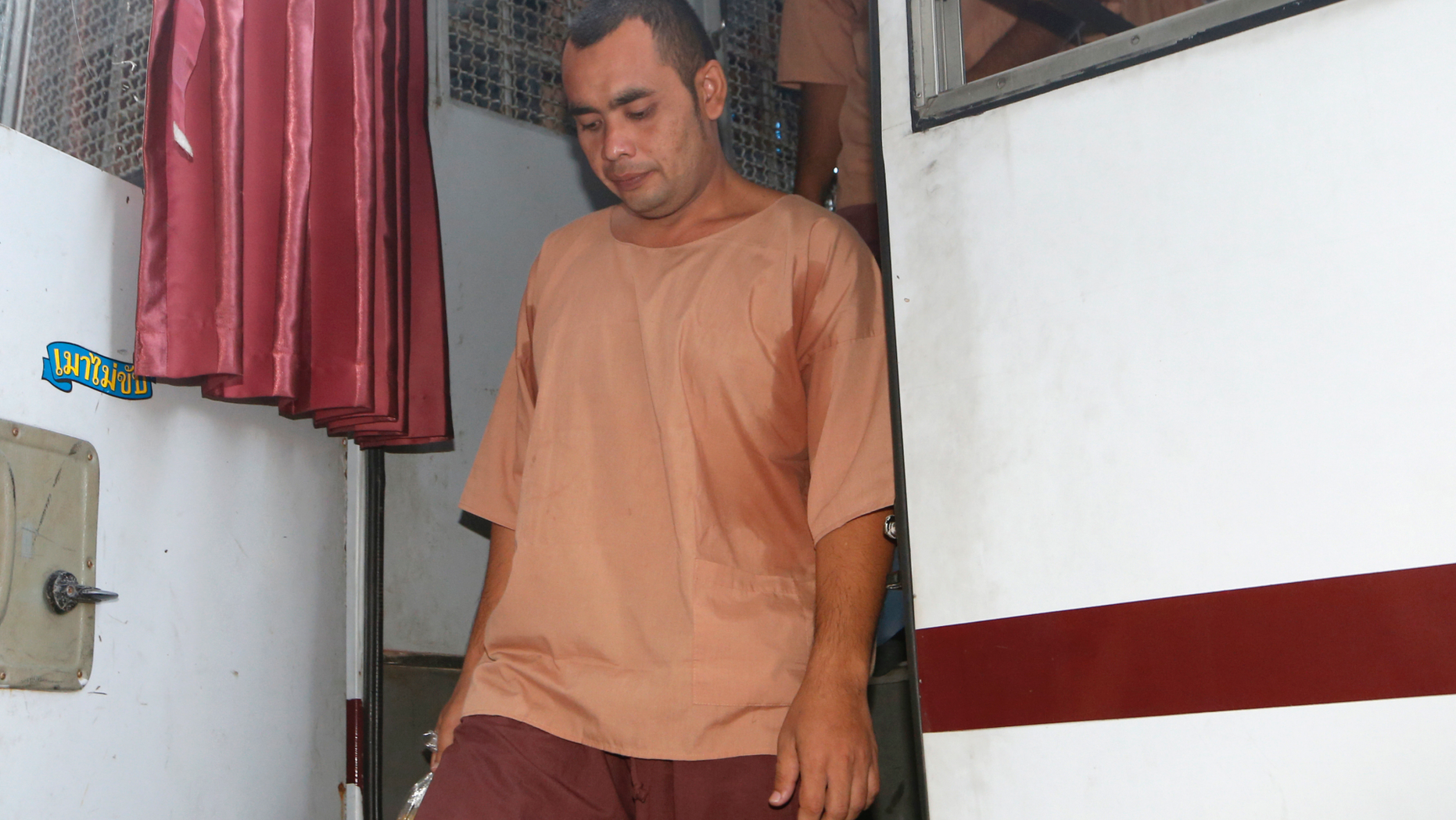 Tarmizi Tohtayong exits a prison bus after arriving at the criminal court in Bangkok, Thailand, Bangkok, Thailand, Tuesday, Sept. 25, 2018. A Thai court has convicted nine young Muslim men from southern Thailand of planning to set off a car bomb in the capital Bangkok found nine guilty of belonging to a secret society, earning each a four-year-prison sentence. (AP Photo/Sakchai Lalit) .
