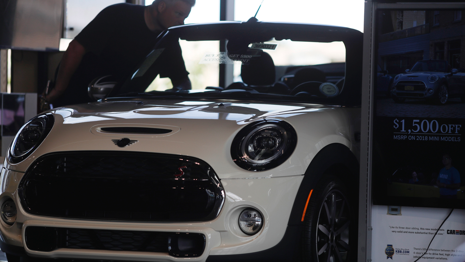 In this Thursday, Aug. 30, 2018, photo, a prospective buyer looks over a 2019 Cooper S convertible on the showroom floor of a Mini dealership in Highlands Ranch, Colo. On Friday, Sept. 14, the Commerce Department releases U.S. retail sales data for August. (AP Photo/David Zalubowski)