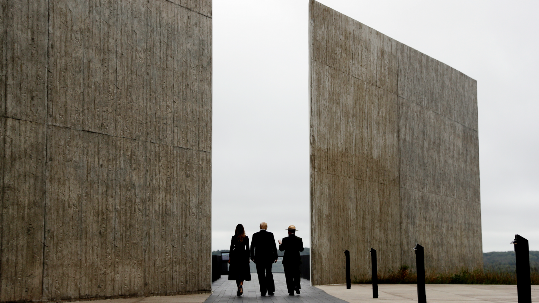 In this Sept. 11, 2018, photo, President Donald Trump and first lady Melania Trump, escorted by Stephen Clark, Superintendent of the National Parks of Western Pennsylvania, walk along the September 11th Flight 93 memorial in Shanksville, Pa. Trump says the Sept. 11 memorial in Shanksville renewed his resolve to push for his stalled southern border wall. Trump tells Hill.TV in an interview published Sept. 19 that he marveled at the Flight 93 National Memorial during a visit. Trump says, “They built this gorgeous wall where the plane went down.” He says, “What they did is incredible,” adding: “They have a series of walls, I’m saying, it’s like perfect. So, so, we are pushing very hard.” (AP Photo/Evan Vucci)