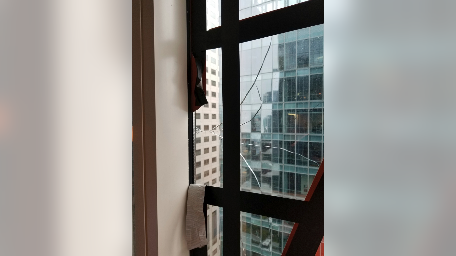 This recent but undated photo provided by the San Francisco Department of Building Inspection shows a window that has cracked in the Millennium Tower Building in San Francisco. City officials are demanding that managers of the sinking condominium building where a window recently cracked comply with several safety measures needed to keep the public safe. Department of Building Inspection Assistant Director Ronald Tom said Thursday, Sept. 13, 2018 that Millennium Tower management has to repair a window washing crane, inspect all units and install a canopy around the entire perimeter of the 58-story building by Friday afternoon. (Department of Building Inspection via AP)