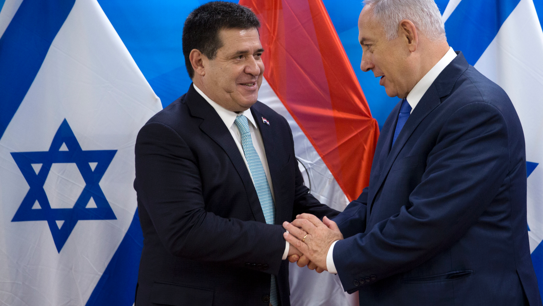 FILE - In this May 21, 2018 file photo, Israeli Prime Minister Benjamin Netanyahu, right, speaks with Paraguay's President Horacio Cartes during their meeting at the Prime Minister's office in Jerusalem. Paraguay’s government says it’s moving its embassy in Israel out of Jerusalem and back to Tel Aviv, less than four months after opening the new mission, Foreign Minister Luis Alberto Castiglioni announced Wednesday, Sept. 5, 2018. (AP Photo/Sebastian Scheiner, Pool, File)
