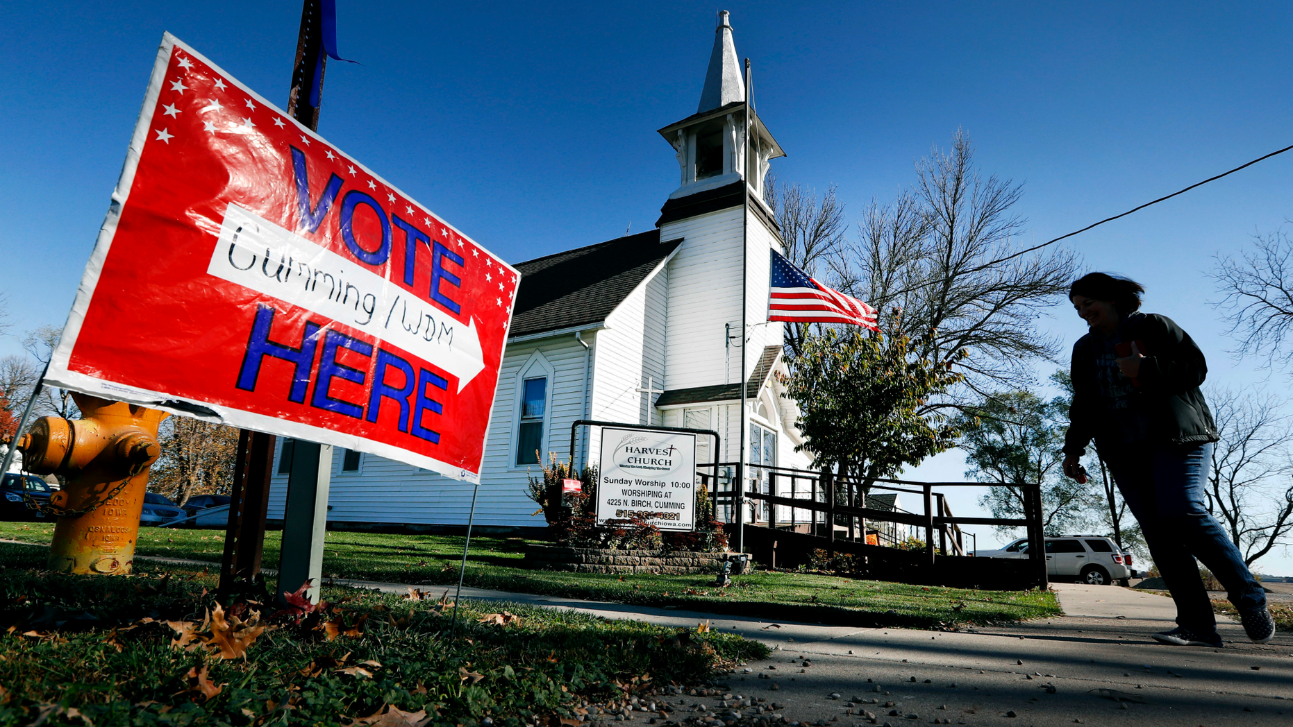 FILE - In this Tuesday, Nov. 8, 2016 file photo, a local resident leaves a church after voting in the general election in Cumming, Iowa. Religion's role in politics and social policies is in the spotlight heading toward the midterm elections, yet relatively few Americans consider it crucial that a candidate be devoutly religious or share their religious beliefs, according to an AP-NORC national poll conducted Aug. 16-20, 2018. (AP Photo/Charlie Neibergall)