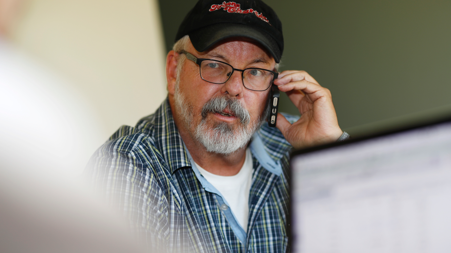 Tom Sullivan, a candidate for a Colorado State Senate district, confers with his campaign manager Kris Grant while making campaign calls from Sullivan's home in Centennial, Colo., on Thursday, Sept. 20, 2018. Sullivan, whose son Alex was killed by James Holmes as he celebrated his 27th birthday in the Aurora theater, said he is encouraged that the state has maintained the post-Aurora ammunition limits and is calling for further gun control as he runs for a Colorado state House seat. Sullivan sees long-term promise in gun-control efforts by Parkland students and survivors of other mass shootings. (AP Photo/David Zalubowski)