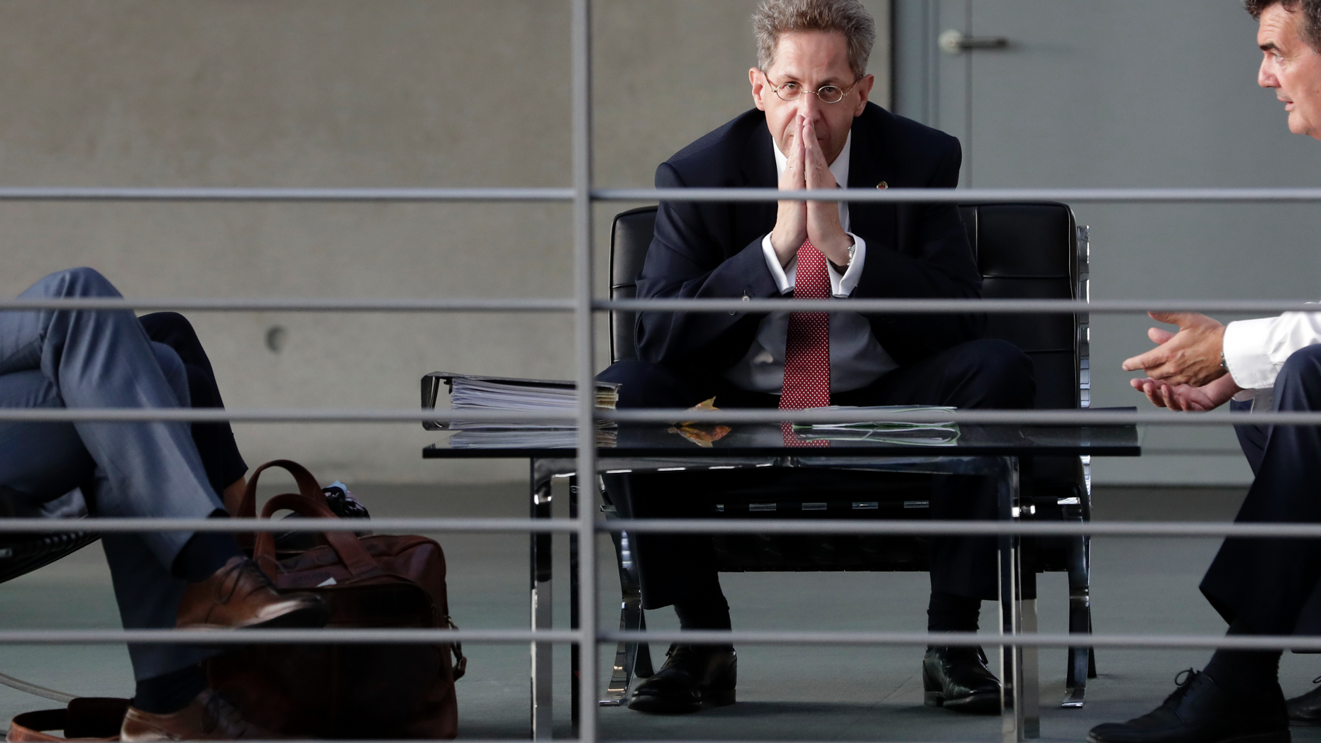 FILE-- In this Wednesday, Sept. 12, 2018 photo Hans-Georg Maassen, center, head of the German Federal Office for the Protection of the Constitution, waits for the beginning of a hearing at the home affairs committee of the German federal parliament, Bundestag, in Berlin, Germany. The leaders of Germany's three governing parties are meeting in Berlin on Tuesday to decide the fate of the country's domestic intelligence chief amid calls for him to be fired over his approach to far-right extremism. (AP Photo/Michael Sohn, file)