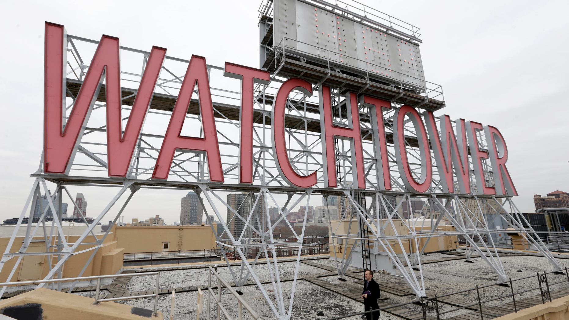 File - In this Wednesday, Dec. 9, 2015, file photo, the iconic Watchtower sign is seen on the roof of 25-30 Columbia Heights, then world headquarters of the Jehovah's Witnesses, in the Brooklyn borough of New York. Two women who were sexually abused as children say the Jehovah's Witnesses failed to report their abuser to authorities in Montana, and instead expelled him from the congregation as punishment until he repented. The Thompson Falls trial that begins Monday, Sept. 24, 2018, is one of dozens of lawsuits filed nationwide over the last decade alleging mismanagement of sexual abuse claims by Jehovah's Witness clergy and members. (AP Photo/Seth Wenig)