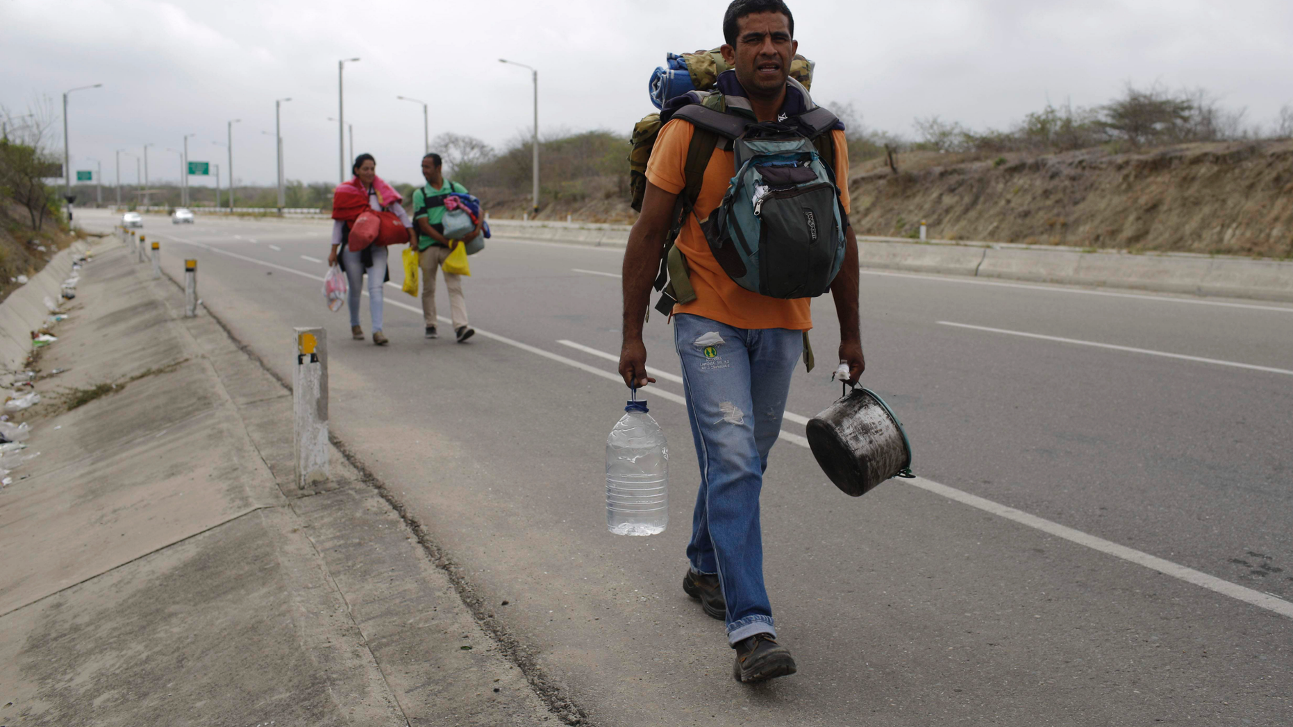 Venezuelan Omar Mujica, a car mechanic, walks to Lima, along the shoulder of the Pan-American Highway, as other Venezuelan migrants follow, after crossing the border from Ecuador into Peru, near Tumbes, Peru, Sunday, Aug. 26, 2018. Mujica, from Barquisimeto, said his car broke down before he started his trip, two weeks ago, and left it behind, unable to sell it. The U.N. estimates 2.3 million Venezuelans have fled since 2014 as the country with the world's largest proven oil reserves plummets into an economic crisis worse than the Great Depression. (AP Photo/Martin Mejia)