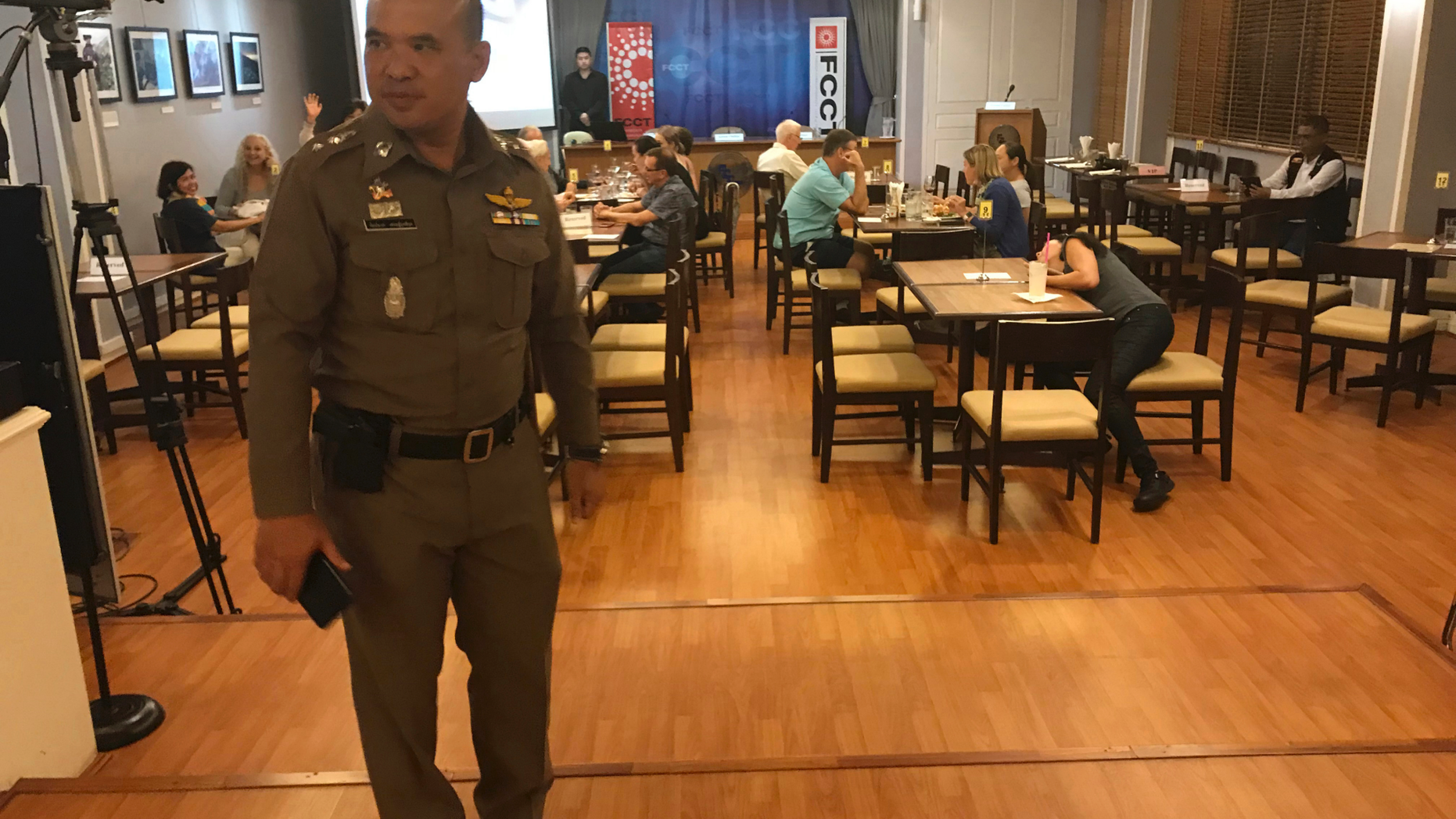 In this Thursday, Sept. 6, 2018, photo, a Thai policeman stands inside Foreign Correspondents' Club of Thailand during an event titled: "Will Myanmar's General Ever Face Justice for International Crimes" in Bangkok, Thailand. Police shut down a forum organized by foreign journalists to discuss whether senior military officers in Myanmar should face justice for alleged human rights abuses committed by their forces against Rohingya Muslims and other ethnic minorities. (AP Photo/Tassanee Vejpongsa)