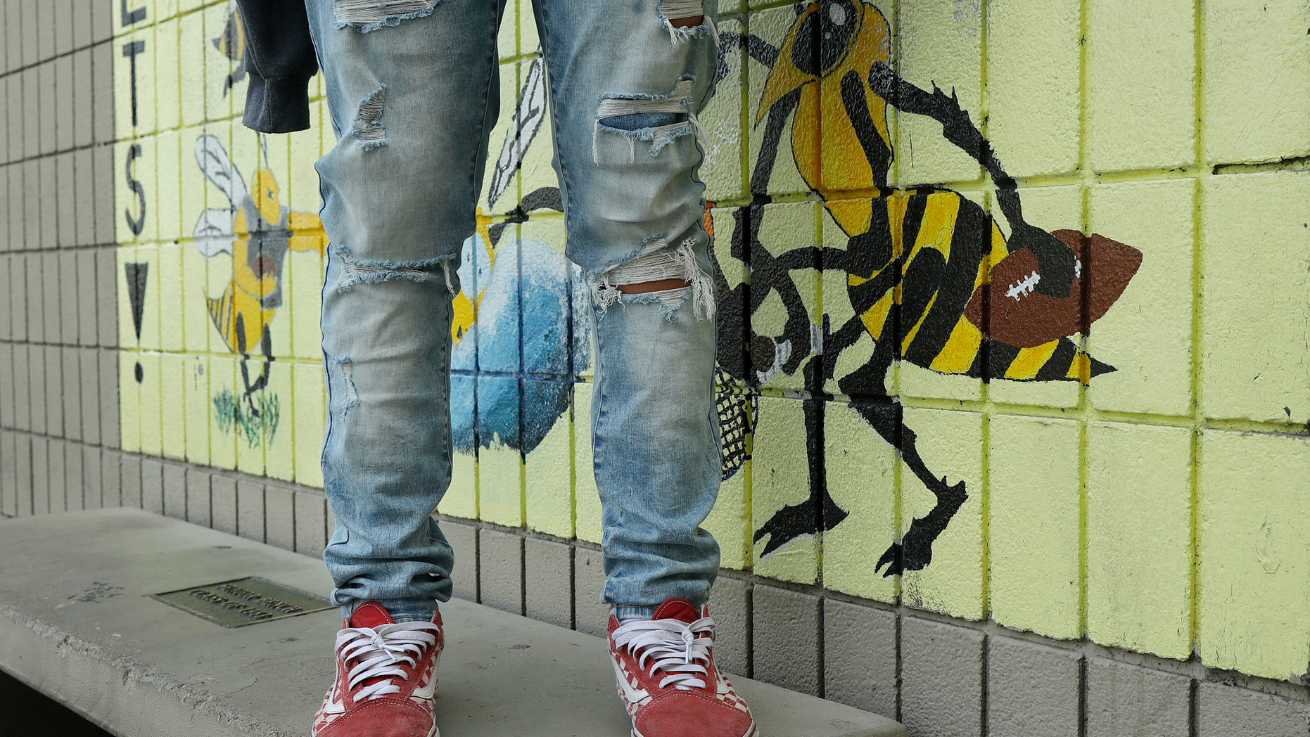 An Alameda High School student poses for photos wearing ripped jeans on the school's campus in Alameda, Calif., Thursday, Aug. 23, 2018. The relaxed new dress code at public schools in the small city of Alameda, across the bay from San Francisco, is intentionally specific: Midriff-baring shirts are acceptable attire, so are tank tops with spaghetti straps and other once-banned items like micro-mini skirts and short shorts. (AP Photo/Jeff Chiu)