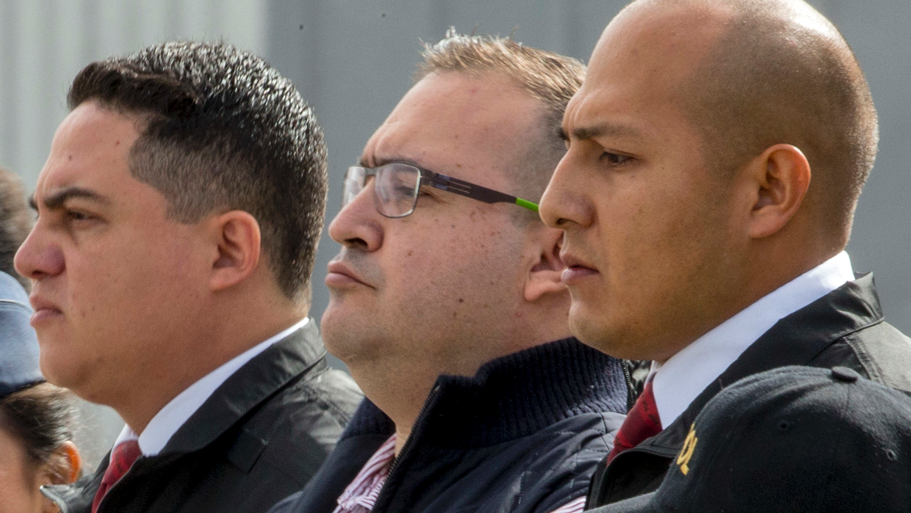 FILE- In this July 17, 2017 file photo, Mexico's former Veracruz state Gov. Javier Duarte, center, is escorted by police to an aircraft as he is extradited to Mexico City, at an Air Force base in Guatemala City. Mexican prosecutors said Thursday, Sept. 27, 2018, that Duarte pleaded guilty to charges of organized crime and money laundering. (AP Photo/Moises Castillo, File)