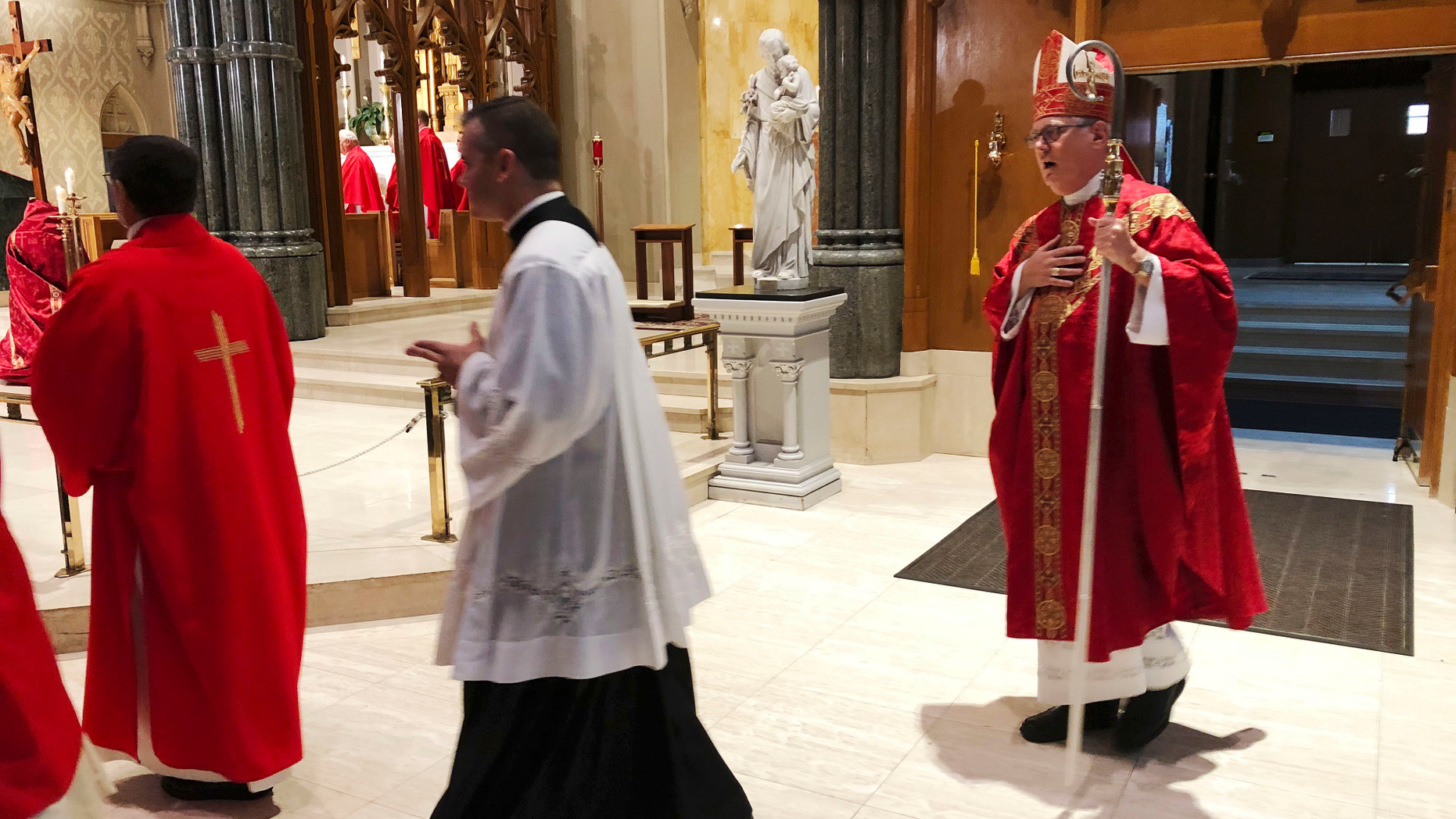 Providence diocese Bishop Thomas Tobin, right, enters the during the processional at the Cathedral of Saints Peter and Paul in Providence, R.I., Friday, Sept. 14, 2018, for a day of prayer and penance he called for due to the sex abuse scandal in the Roman Catholic Church. (AP Photo/Jennifer McDermott)
