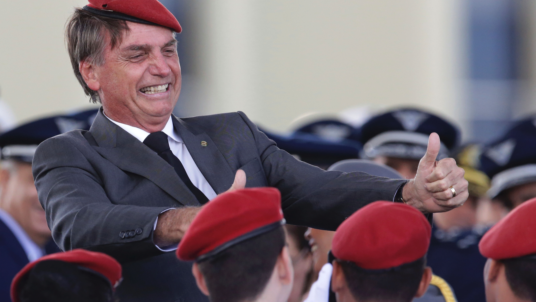FILE - In this April 19, 2018 file photo, presidential hopeful, conservative Brazilian lawmaker Jair Bolsonaro flashes two thumbs up as he poses for a photo with cadets during a ceremony marking Army Day, in Brasilia, Brazil. Bolsonaro, the leading candidate in Brazil's presidential race was discharged from the hospital Saturday, Sept. 29, 2018, where he was being treated for a knife wound to his abdomen. (AP Photo/Eraldo Peres, File)