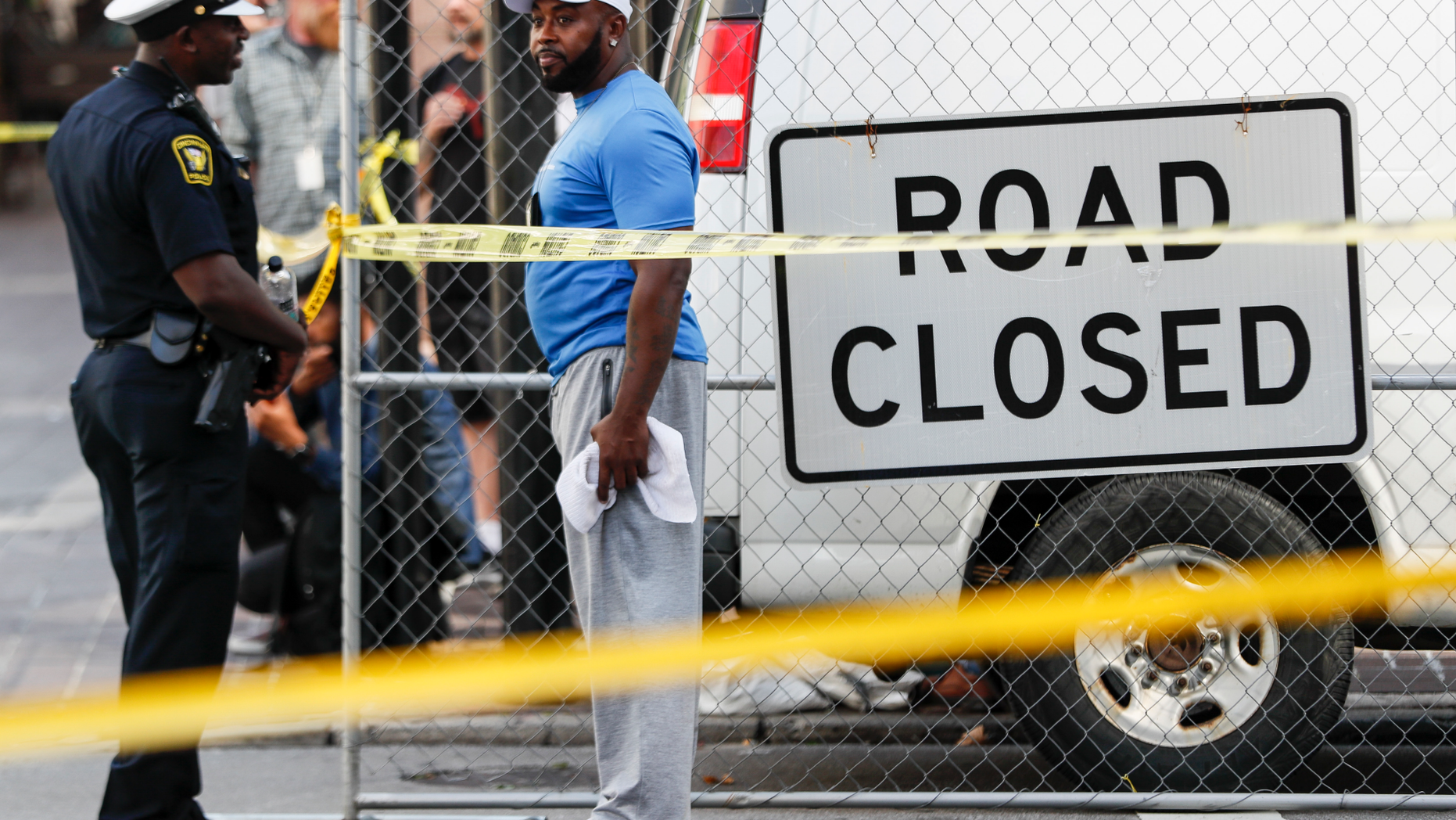 Pedestrians stand behind a police line as emergency personnel and police respond to reports of a shooting near Fountain Square, Thursday, Sept. 6, 2018, in downtown Cincinnati. (AP Photo/John Minchillo)