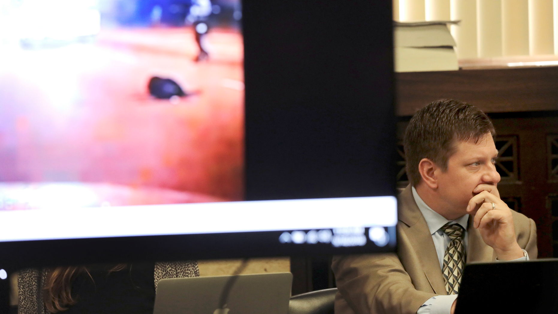 Chicago police Officer Jason Van Dyke listens at right during the second day of his murder trial for the 2014 killing of Laquan McDonald on Tuesday, Sept. 18, 2018, as a video image of McDonald body lying in the street is displayed in court at the Leighton Criminal Court Building in Chicago. (Antonio Perez/Chicago Tribune via AP, Pool)
