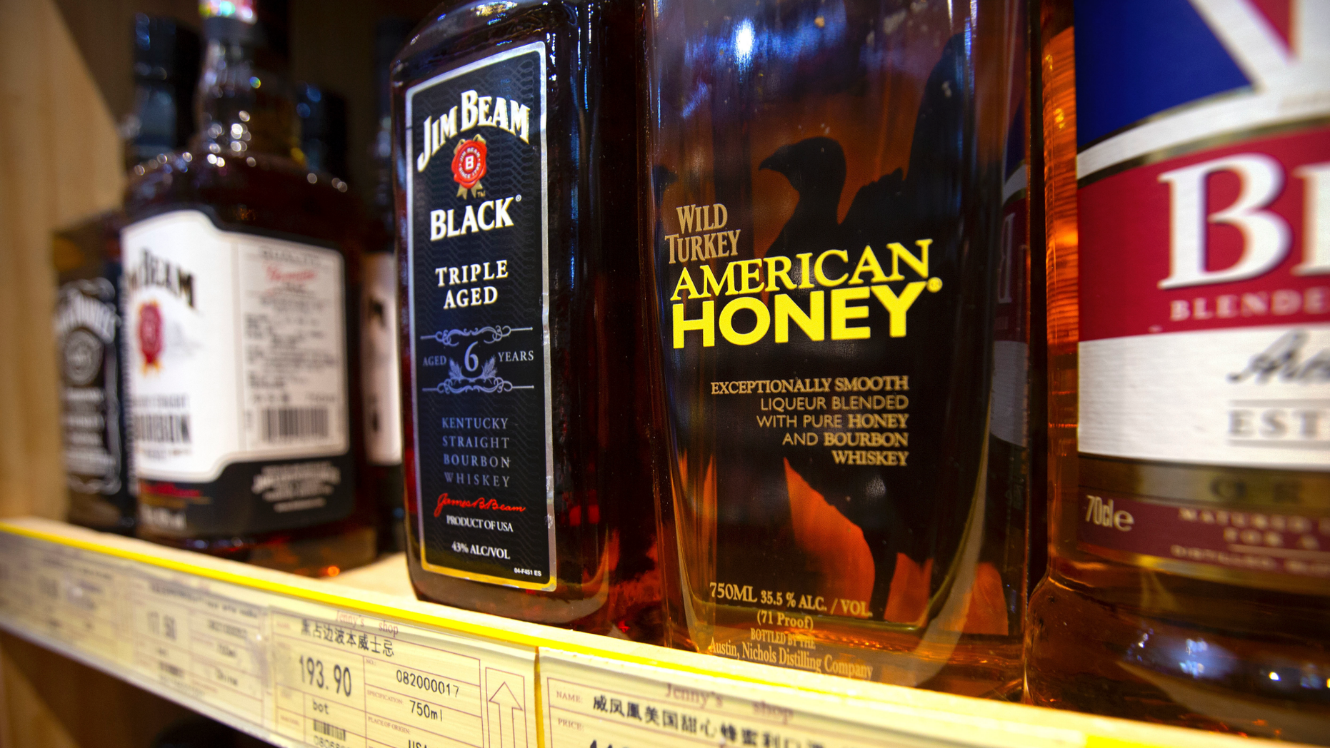 FILE - In this July 7, 2018, file photo, whiskeys distilled and bottled in the U.S. are displayed for sale in a grocery store in Beijing. Kentucky's bourbon distilleries turned up the pace of production again last year, boosting overall inventory to 7.5 million barrels of aging whiskey, the highest volume since 1972. (AP Photo/Mark Schiefelbein, File)