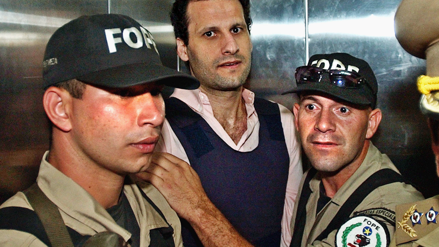 FILE - In this Nov. 17, 2003 file photo, Lebanese citizen Assad Ahmad Barakat, who was then facing tax evasion charges, is escorted by police to a courthouse in Asuncion, Paraguay. On Friday, Sept. 21, 2018, federal police in Brazil arrested Barakat, a fugitive accused of belonging to Lebanon's Hezbollah militia and of being a key financier of terrorism. (AP Photo/Jorge Saenz, File)