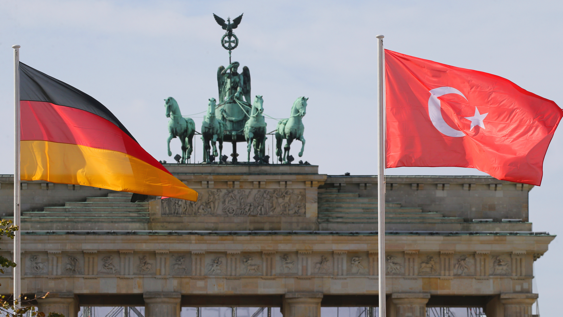 In this Sept. 26, 2018 photo the German and the Turkish flag flutter in front of the Brandenburg Gate in Berlin where Turkish President Recep Tayyip Erdogan is expected to arrive on Thursday, Sept. 27, 2018 for a three-day official state visit. (Wolfgang Kumm/dpa via AP)