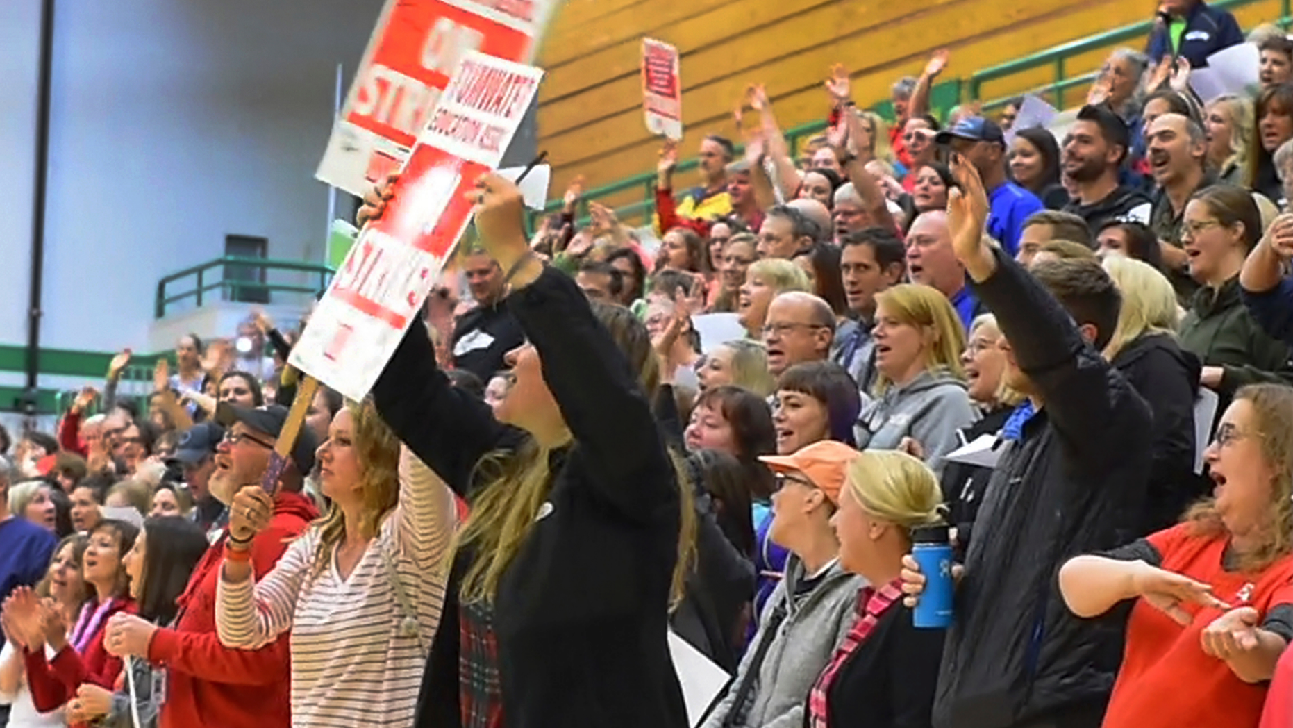 Meeting in the Tumwater High School gymnasium Monday, Sept. 17, 2018, in Tumwater, Wash. Black Hills High School teacher Matt Bell leads a jubilant group of his fellow educators in the Neil Diamond song "Sweet Caroline" as they celebrate a 98% ratification of their new two-year contract with the district. (Steve Bloom/The Olympian via AP)