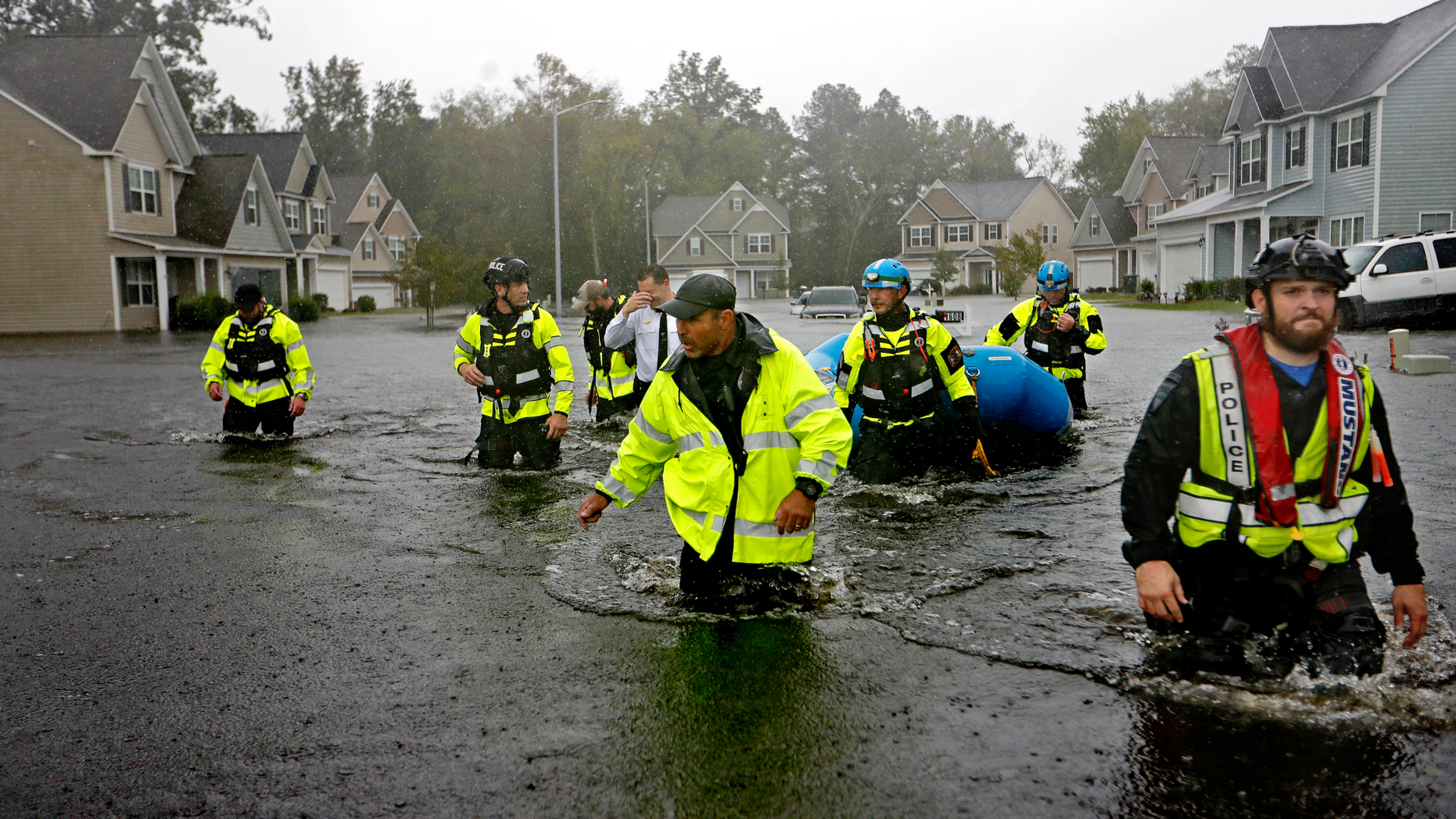 Members of the North Carolina Task Force urban search and rescue team wade through a flooded neighborhood looking for residents who stayed behind as Florence continues to dump heavy rain in Fayetteville, N.C., Sunday, Sept. 16, 2018. (AP Photo/David Goldman)