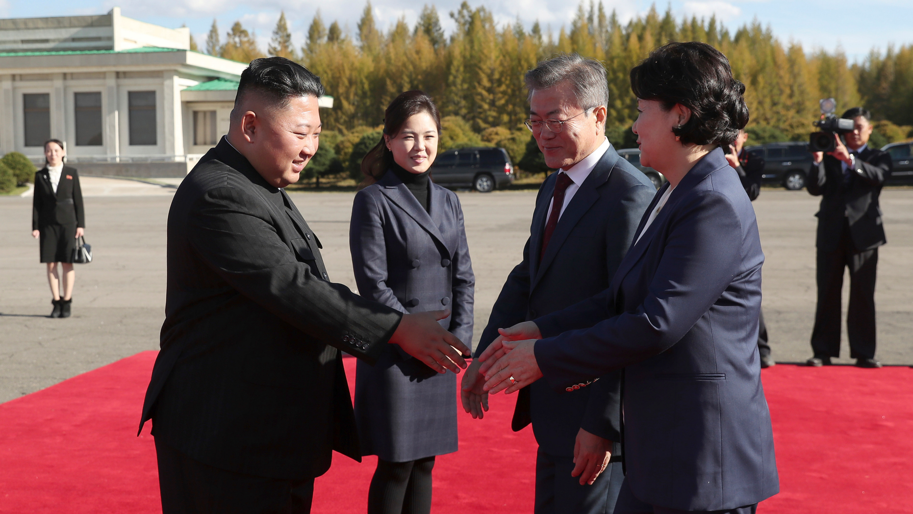 North Korean leader Kim Jong Un, left, flanked by his wife Ri Sol Ju, second from left, bids farewell to South Korean President Moon Jae-in, second from right, and his wife Kim Jung-sook, at Samjiyon airport, in North Korea, Thursday, Sept. 20, 2018. A beaming South Korean President Moon, freshly returned home Thursday from a whirlwind three-day summit with Kim Jong Un, said the North Korean leader wants the U.S. secretary of state to visit Pyongyang soon for nuclear talks, and also hopes for a quick follow-up to his June summit with President Donald Trump. (Pyongyang Press Corps Pool via AP)