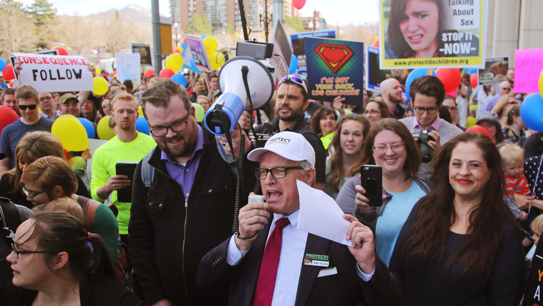 FILE - In this March 30, 2018, file photo, Sam Young, center, speaks to a group of people during a march to church headquarters, in Salt Lake City. Young, a Mormon who has led a campaign criticizing the church's practice of allowing closed-door, one-on-one interviews of youth by lay leaders, will have to wait to find out if he'll be kicked out of the religion. Young said late Sunday, Sept. 9, 2018, that local church leaders didn't make a decision following a disciplinary council at his congregation in Houston. Young says they didn't say when they will decide. (AP Photo/Rick Bowmer, File)