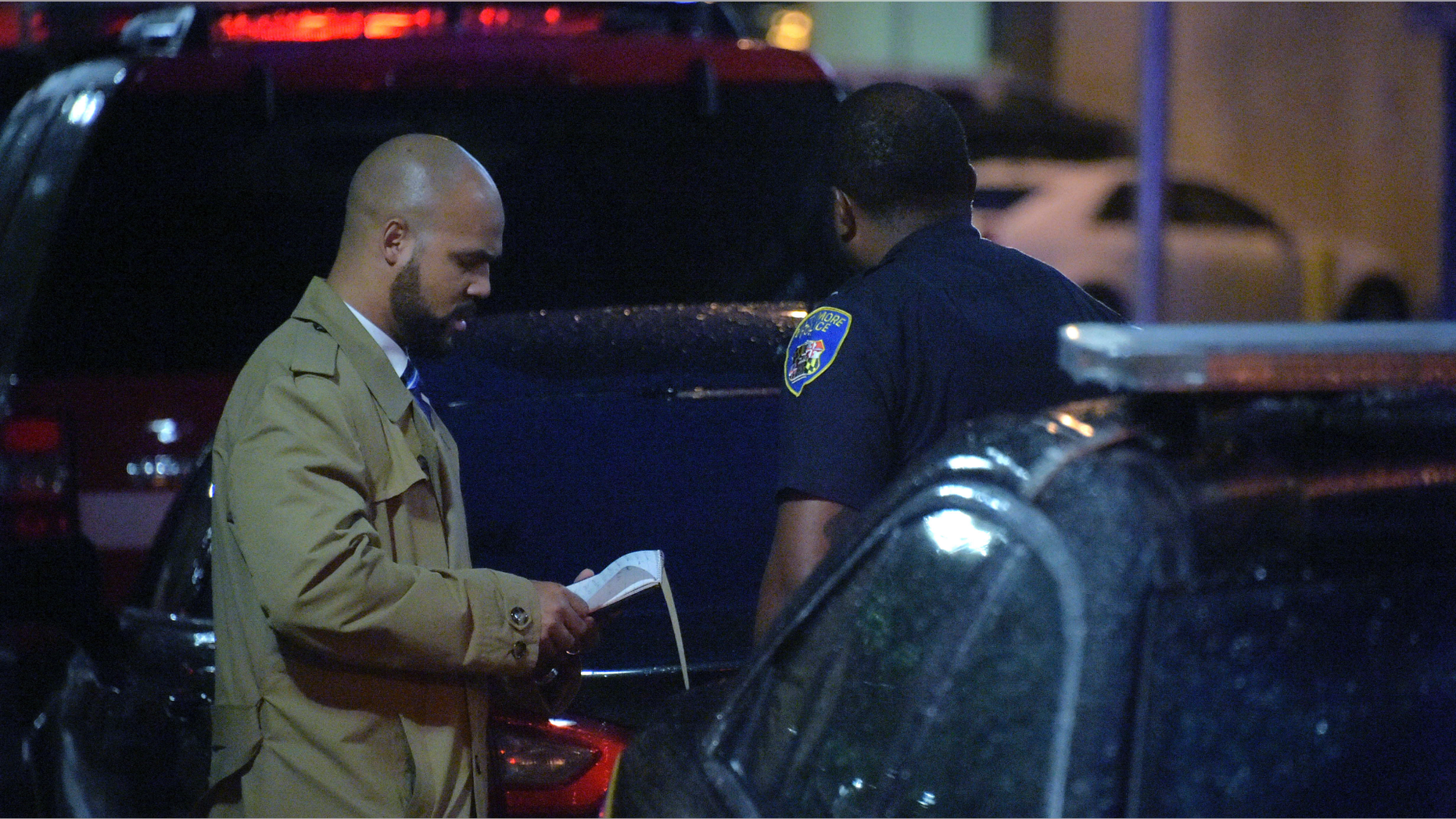 A detective talks with a member of the Baltimore Police outside University of Maryland Shock Trauma, following a shooting in Baltimore on Sunday, Sept. 23, 2018. The shootout between a man in a violence-prone Baltimore district and a police officer taking part in a crime suppression initiative has left the officer wounded and the suspect dead Sunday evening, Baltimore's interim police chief said. (Karl Merton Ferron/The Baltimore Sun via AP)