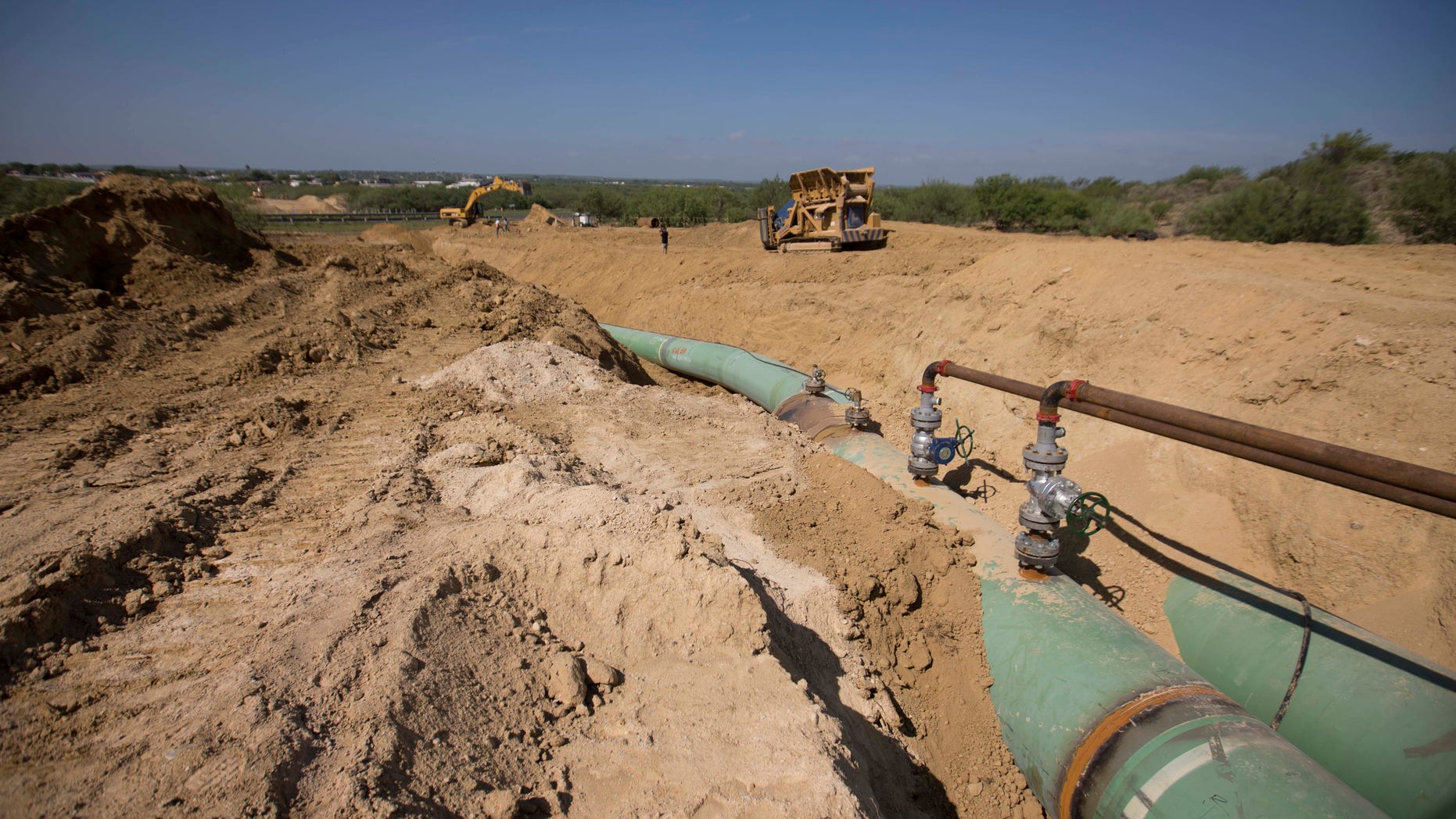 FILE - In this Sept. 7, 2014 photo, new pipelines to carry gas from Texas to Mexico, eventually reaching the city of Guanajuato, are laid underground near General Bravo, in Nuevo Leon state, Mexico. In Mexico's Puebla state, gunmen using local residents as a human shield opened fire on a Mexican army patrol investigating fuel pipeline thefts, killing two soldiers and wounding a third, the military said Thursday, May 4, 2017. (AP Photo/Eduardo Verdugo, File)