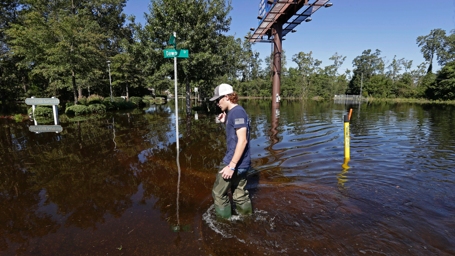 Zachary Conner wades into a flooded neighborhood to check on his girlfriend in Lumberton, N.C., Tuesday, Sept. 18, 2018, following the effects from Hurricane Florence. (AP Photo/Gerry Broome)