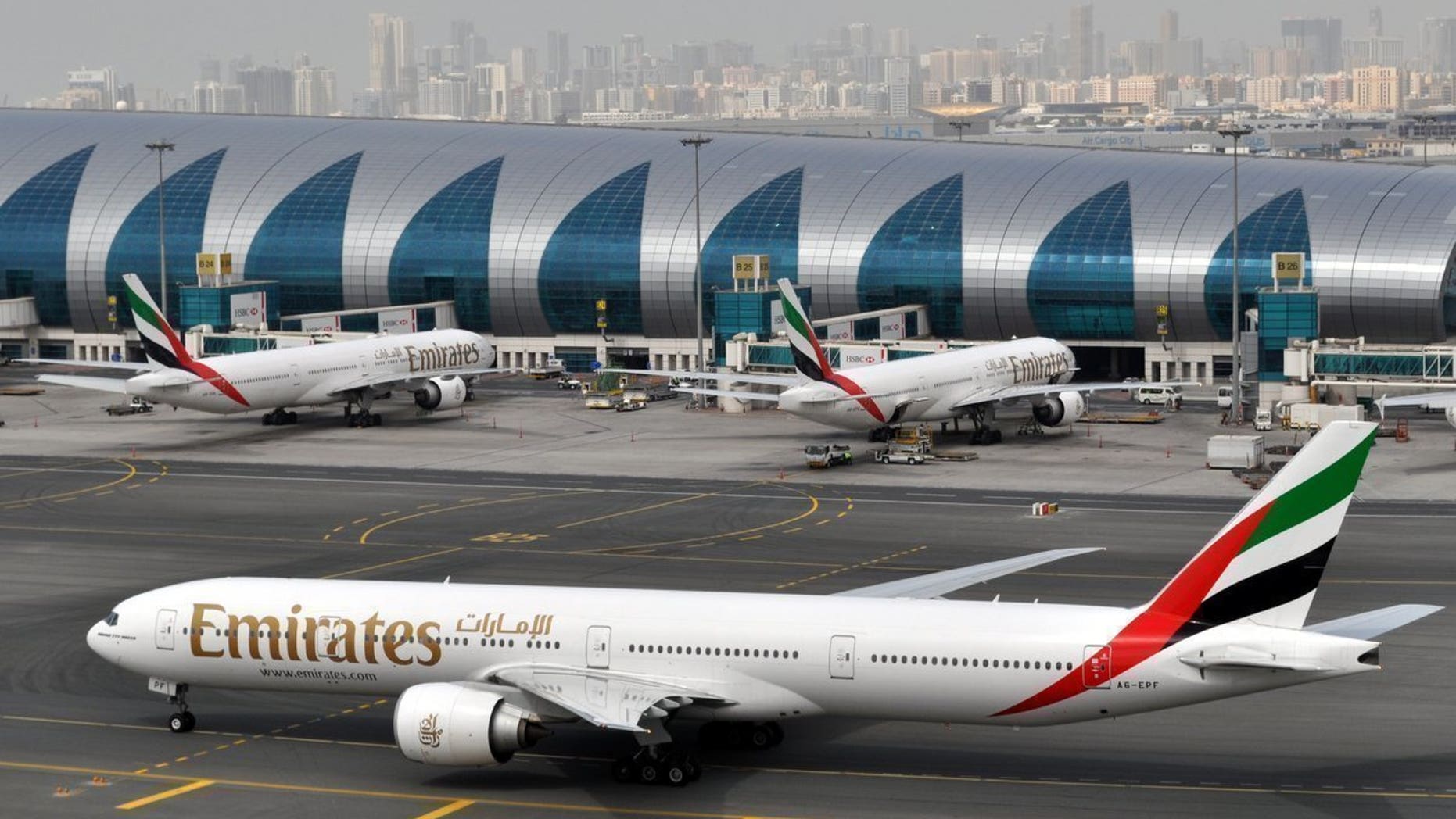 FILE -- In this March 22, 2017 file photo, an Emirates plane taxis to a gate at Dubai International Airport at Dubai International Airport in Dubai, United Arab Emirates. Emirates Group, which operates the Middle East's largest airline, said in a report released Thursday, May 11, 2017, that profits have fallen by 70 percent to $670 million, though revenue increased slightly to around $26 billion. The airline said profits were affected by a turbulent year, including heightened immigration concerns, terror attacks in several European cities, an attempted military coup in Turkey and uncertainty caused by Britain's vote to leave the European Union. (AP Photo/Adam Schreck, File)