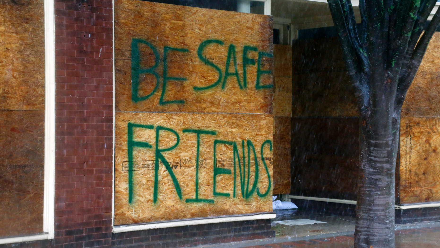 A message on a boarded-up business encourages people to be safe as Hurricane Florence hits downtown New Bern, N.C., on Friday, Sept. 14, 2018. (AP Photo/Chris Seward)