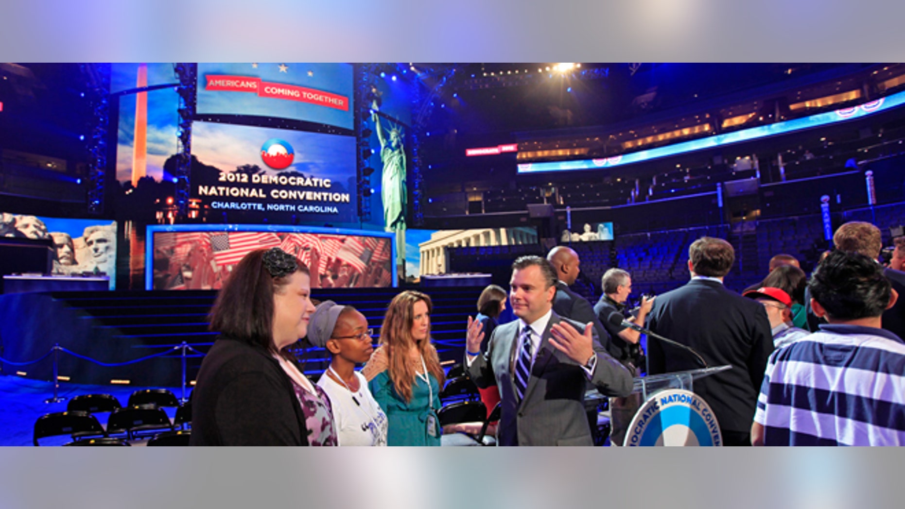 DNCC CEO Steve Kerrigan, center, talks with guests near the main stage during the public unveiling of Democratic National Convention's facilities at Time Warner Arena in Charlotte, N.C., Friday, Aug. 31, 2012. (AP Photo/Chuck Burton)