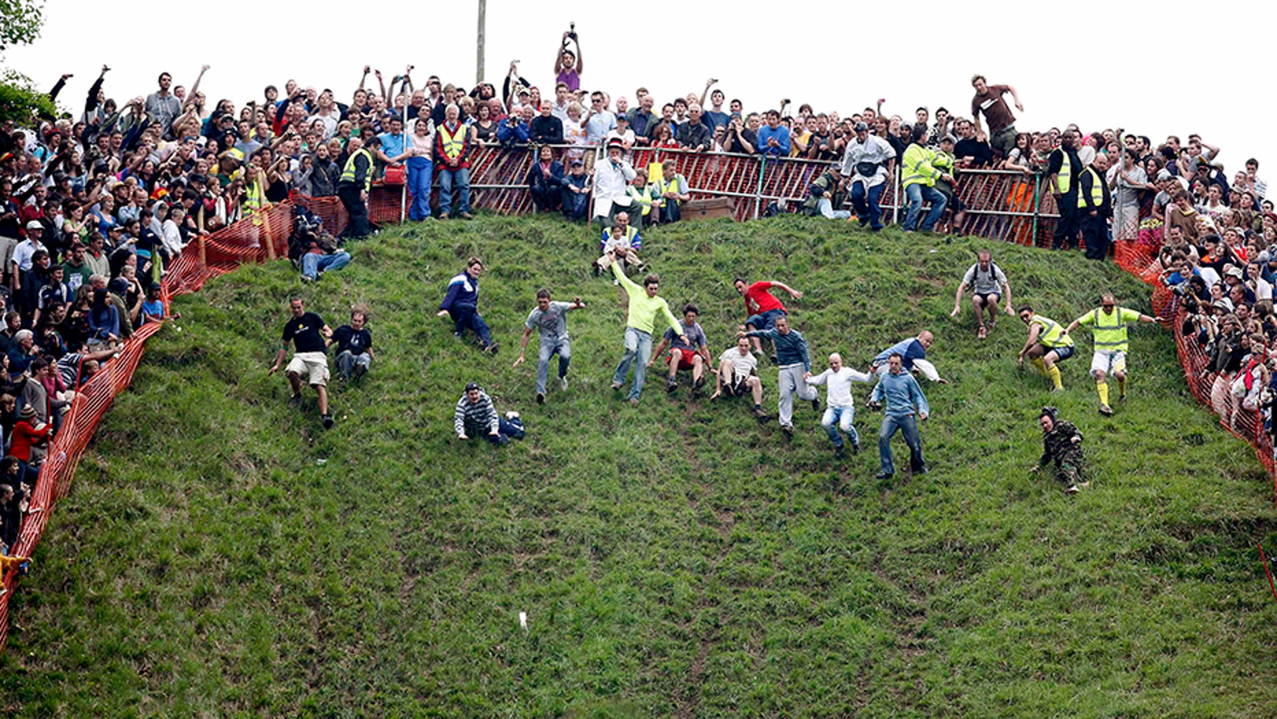 People chase wheels of cheese down steep hill for annual Cheese Roll