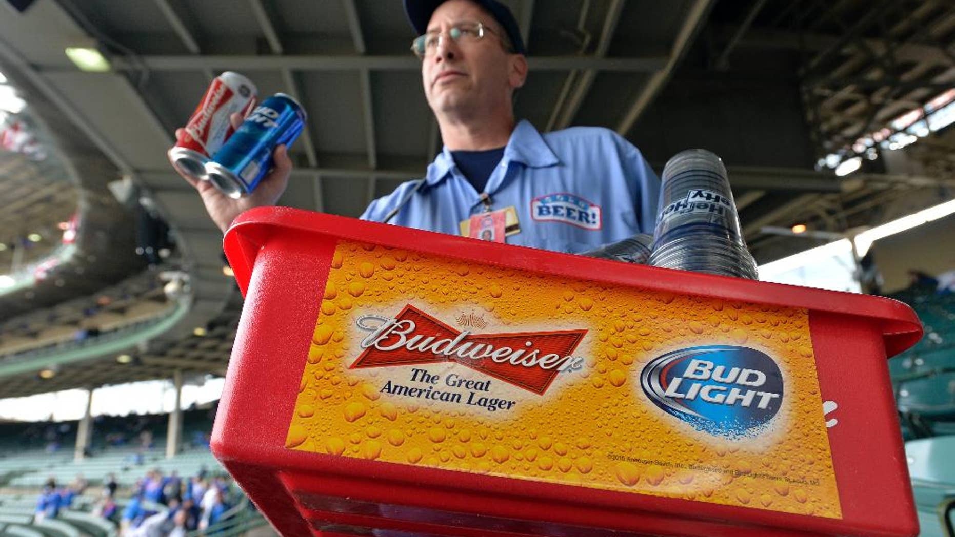 FILE - In this Tuesday, Oct. 13, 2015, file photo, a beer vender holds up Budweiser and Bud Light at Wrigley Field before Game 4 in baseball's National League Division Series between the Chicago Cubs and the St. Louis Cardinals in Chicago. Budweiser's owner Anheuser Busch InBev clinched a preliminary deal earlier this month to take over British beer company SABMiller for around 69 billion pounds ($106 billion). A survey from consulting firm EY on Monday, Oct. 26, 2015, points to more global mega-deals in the year to come. (AP Photo/Paul Beaty, File)