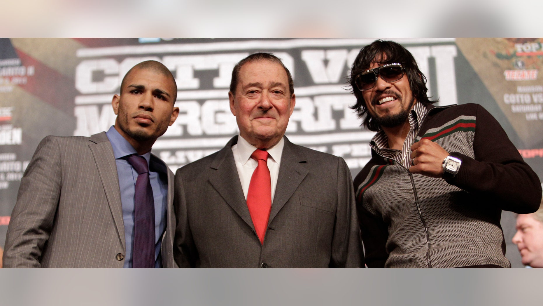 Boxers Miguel Cotto, left, of Puerto Rico, and Antonio Margarito, right, of Mexico, flank promoter Bob Arum during a news conference Wednesday, Nov. 30, 2011 at Madison Square Garden in New York. Cotto will defend his WBA Super World junior middleweight title against Margarito on Saturday, Dec. 3, in New York. (AP Photo/Mary Altaffer)