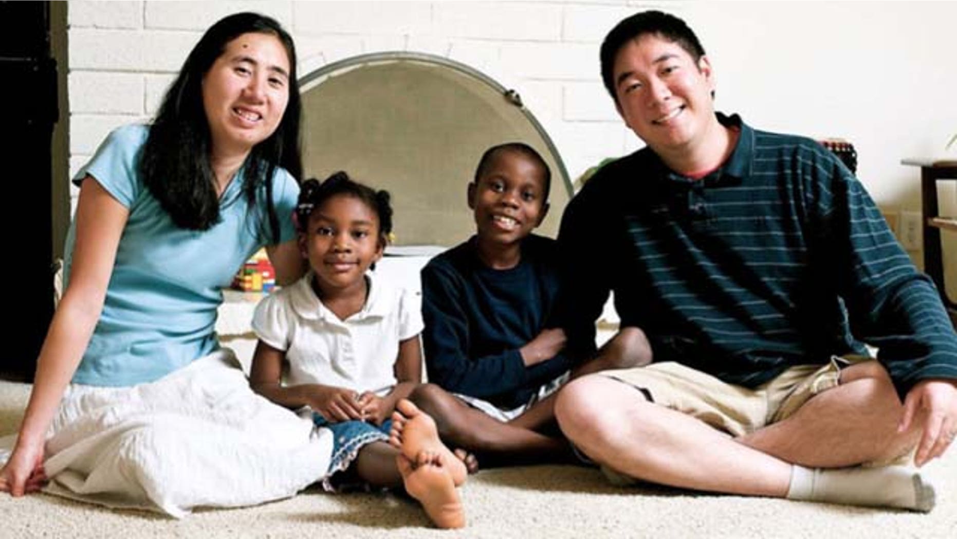 This undated photo provided by the David House Agency shows Matthew, right, and Grace Huang, left, with two of their adopted children, Gloria, center left, and one of their two sons. The couple has been jailed in Qatar on a charge of murder with intent and is accused of starving Gloria, 8, to death, according to a coalition of legal and public relations groups that are working on the case from the U.S. and trying to draw publicity to what they claim is are unjust arrests. (AP Photo/