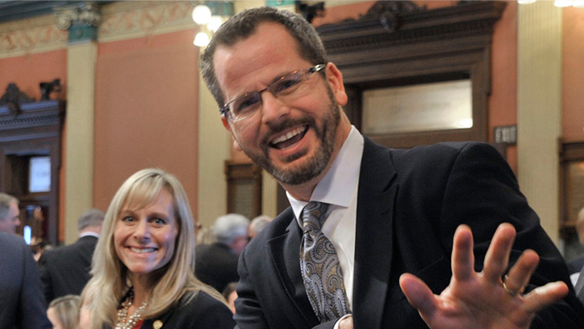 In this Jan. 14, 2015 photo, Michigan state Rep. Cindy Gamrat and state Rep. Todd Courser wave to reporters in the House of Representatives in Lansing.