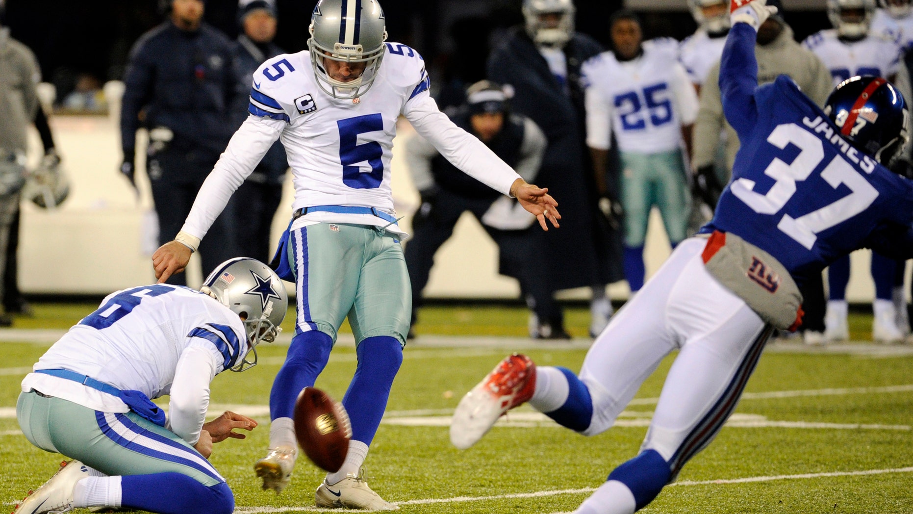 Dallas Cowboys kicker Dan Bailey (5), with Chris Jones holding, kicks a game-winning field goal against the New York Giants during the second half of an NFL football game, Sunday, Nov. 24, 2013, in East Rutherford, N.J.
