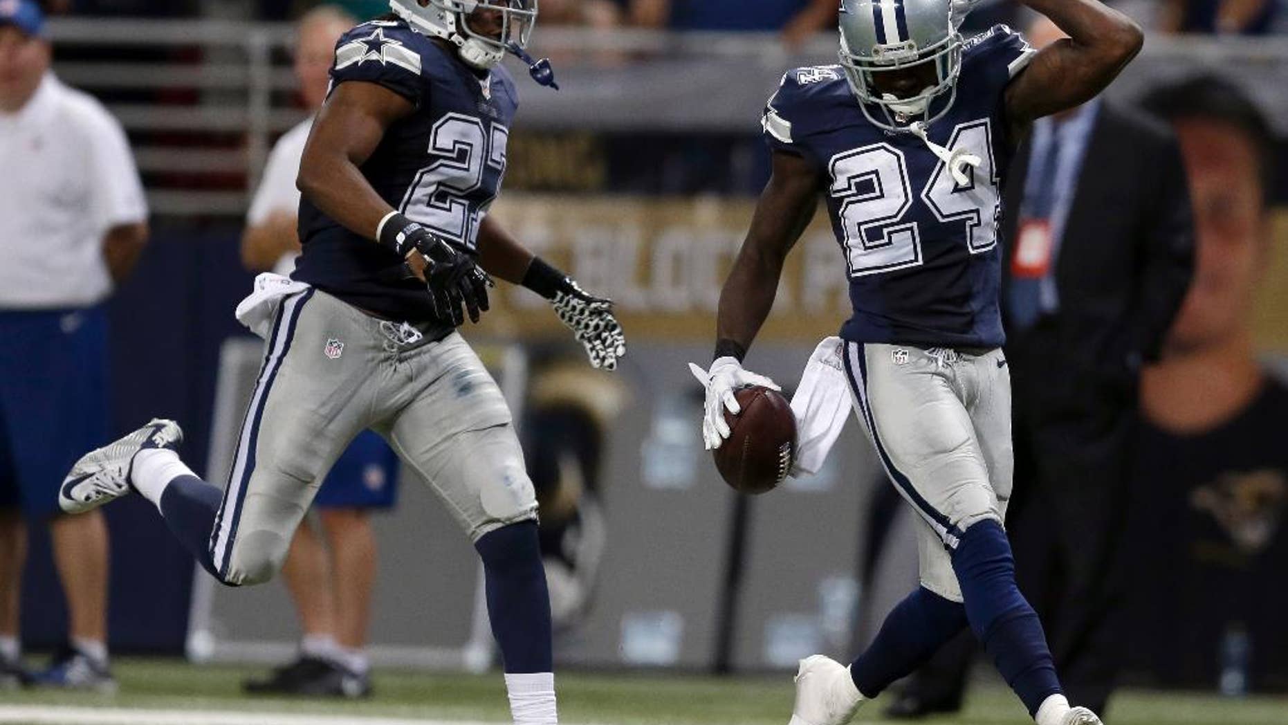 Dallas Cowboys cornerback Morris Claiborne, right, celebrates after intercepting a pass as teammate strong safety J.J. Wilcox watches during the fourth quarter of an NFL football game against the St. Louis Rams, Sunday, Sept. 21, 2014, in St. Louis. The Cowboys won 34-31. (AP Photo/Jeff Roberson)