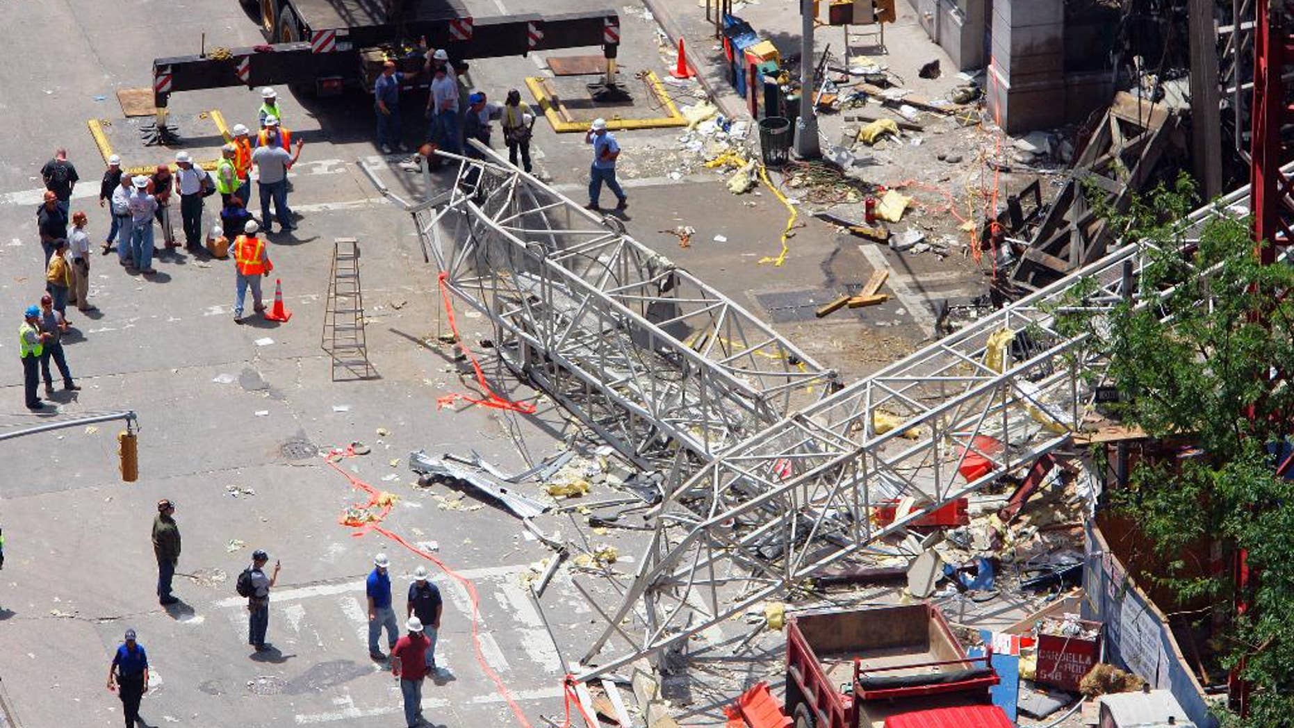 FILE - In this May 30, 2008 file photo, crews work at the scene of a crane collapse on the Upper East Side of New York. The New York City construction crane owner who was acquitted of manslaughter in a collapse that killed two workers has gone on trial again in a civil wrongful death case. Lawyers for the slain workers' families gave opening statements on Friday, May 23, 2014 in the trial of James Lomma, his company and others involved in the accident. (AP Photo/Stephen Chernin, File)