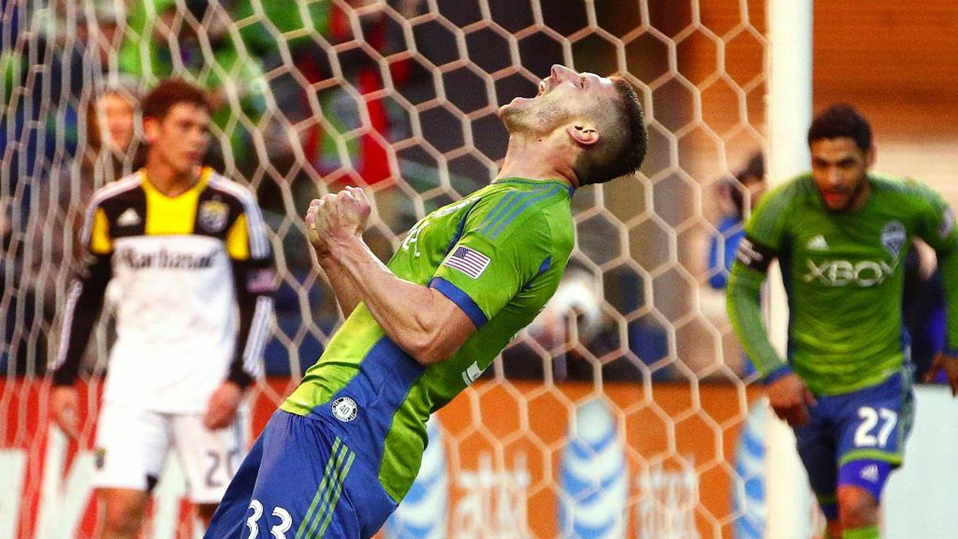 Seattle Sounders midfielder Kenny Cooper celebrates after scoring against Columbus Crew goalkeeper Steve Clark in the first half od an MLS soccer game on Saturday, March 29, 2014, in Seattle, Wash. (AP Photo/The Seattle Times, John Lok) MANDATORY CREDIT TO BOTH THE SEATTLE TIMES AND THE PHOTOGRAPHER; SEATTLE OUT; USA TODAY OUT; MAGAZINES OUT; TV OUT, NO SALES
